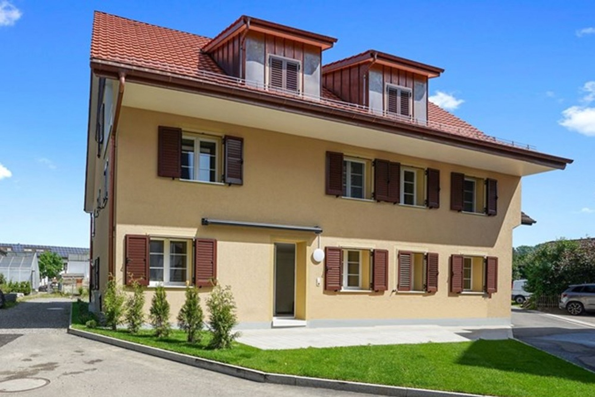 Beiges Wohnhaus mit rotem Ziegeldach