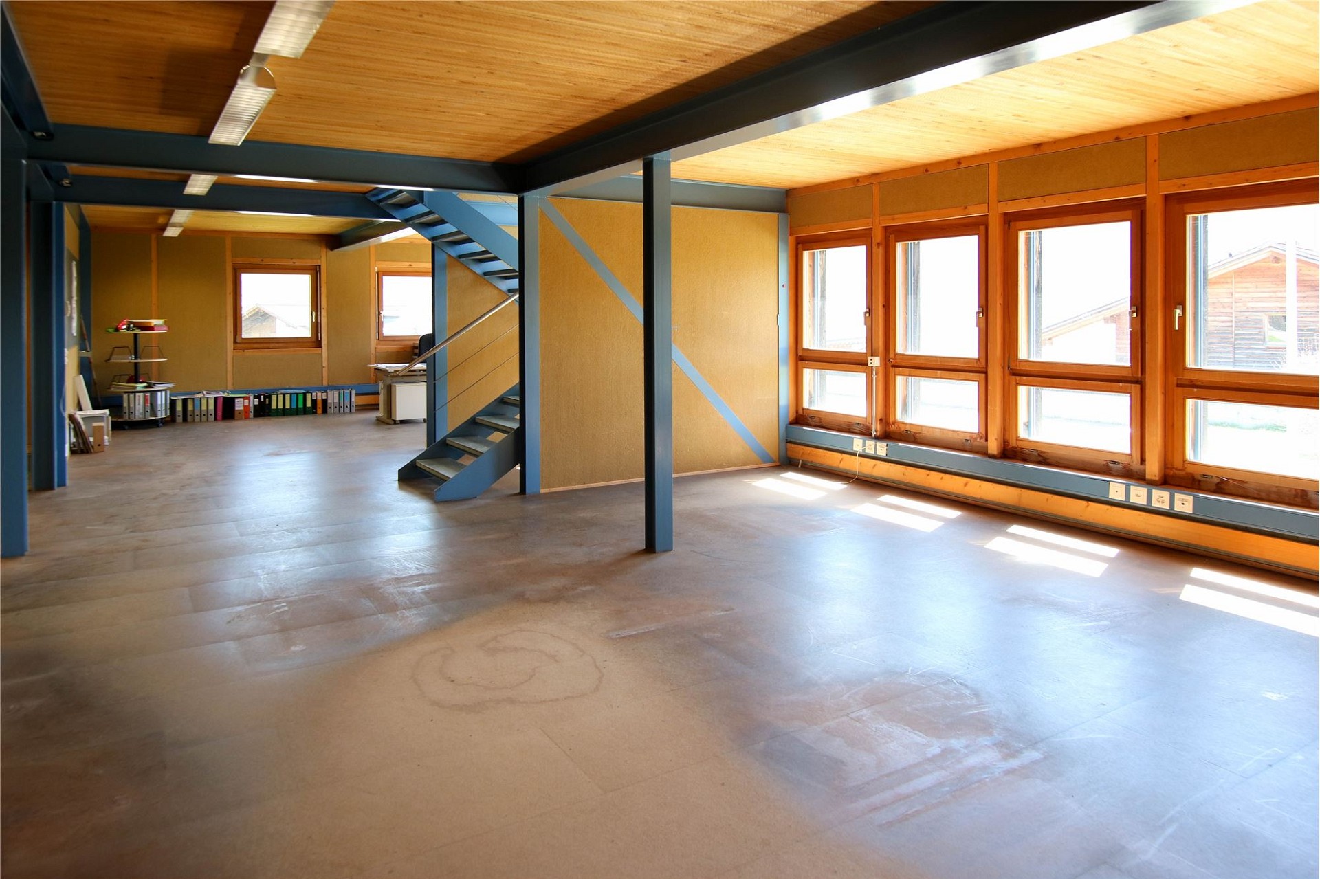 Großer leerer Innenraum mit Treppe und vielen Fenstern