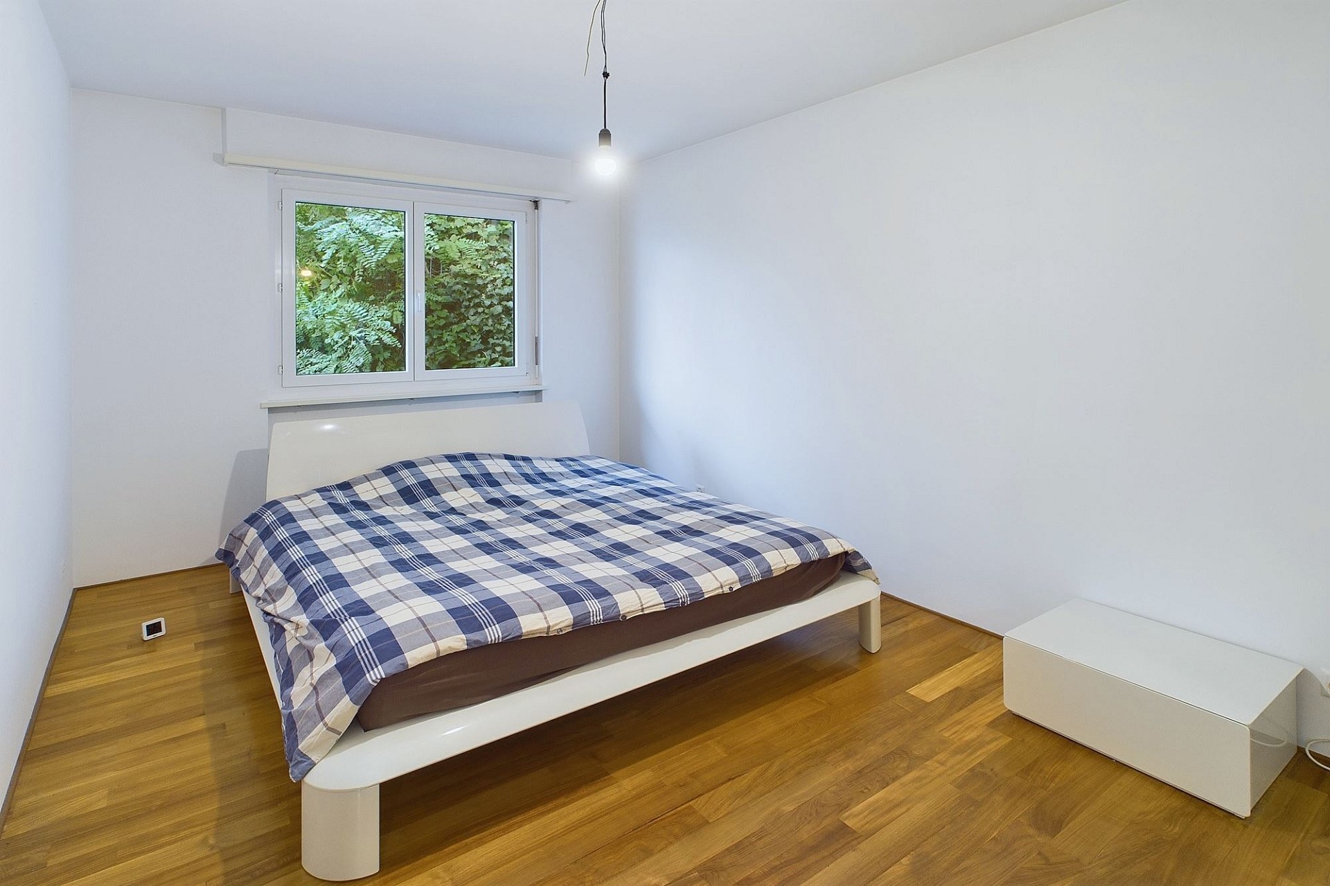 Helles Schlafzimmer mit Bett und Holzfußboden
