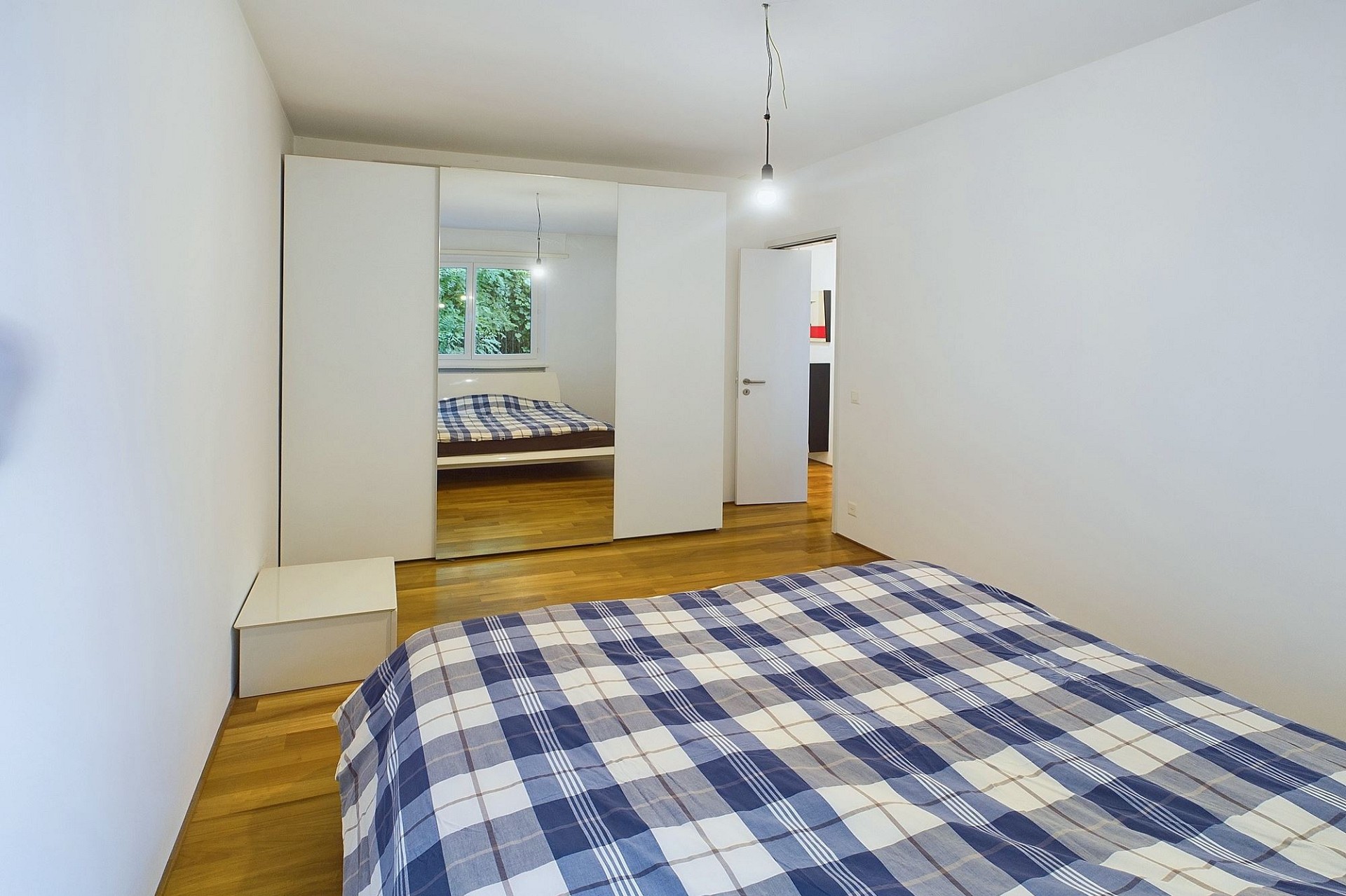 Helles Schlafzimmer mit Doppelbett und Kleiderschrank
