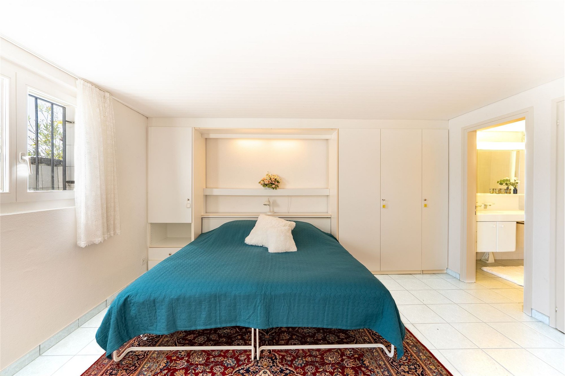 Helles Schlafzimmer mit Bett und Einbauschränken