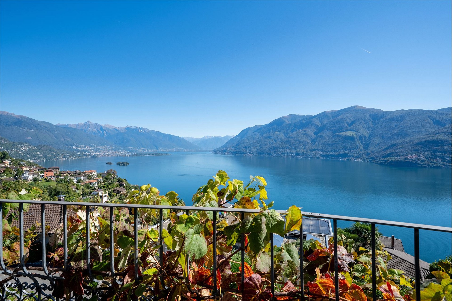 Blick von einer Terrasse auf einen See mit Bergen