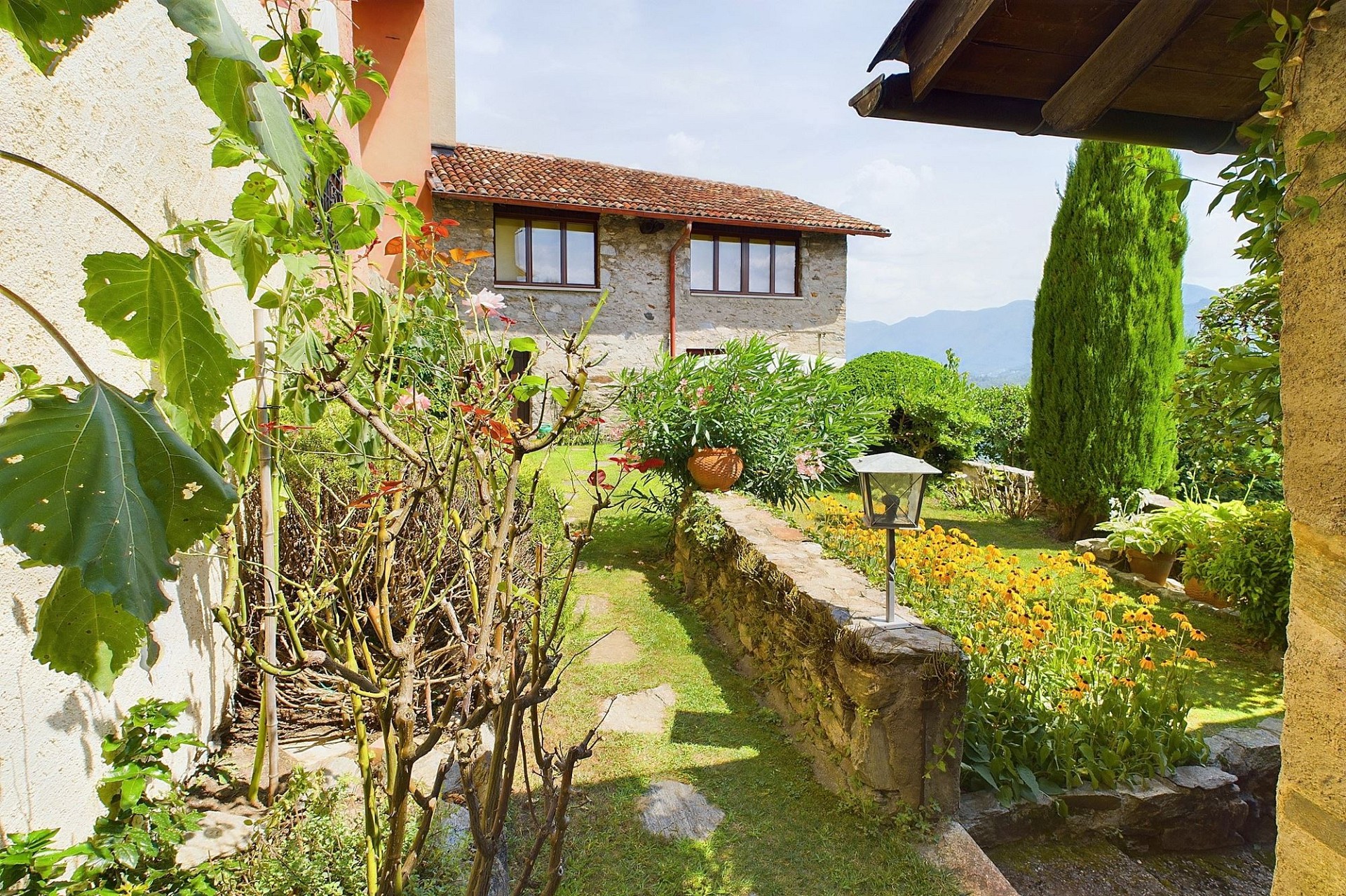 Mediterraner Garten mit Steinhaus und Bergblick