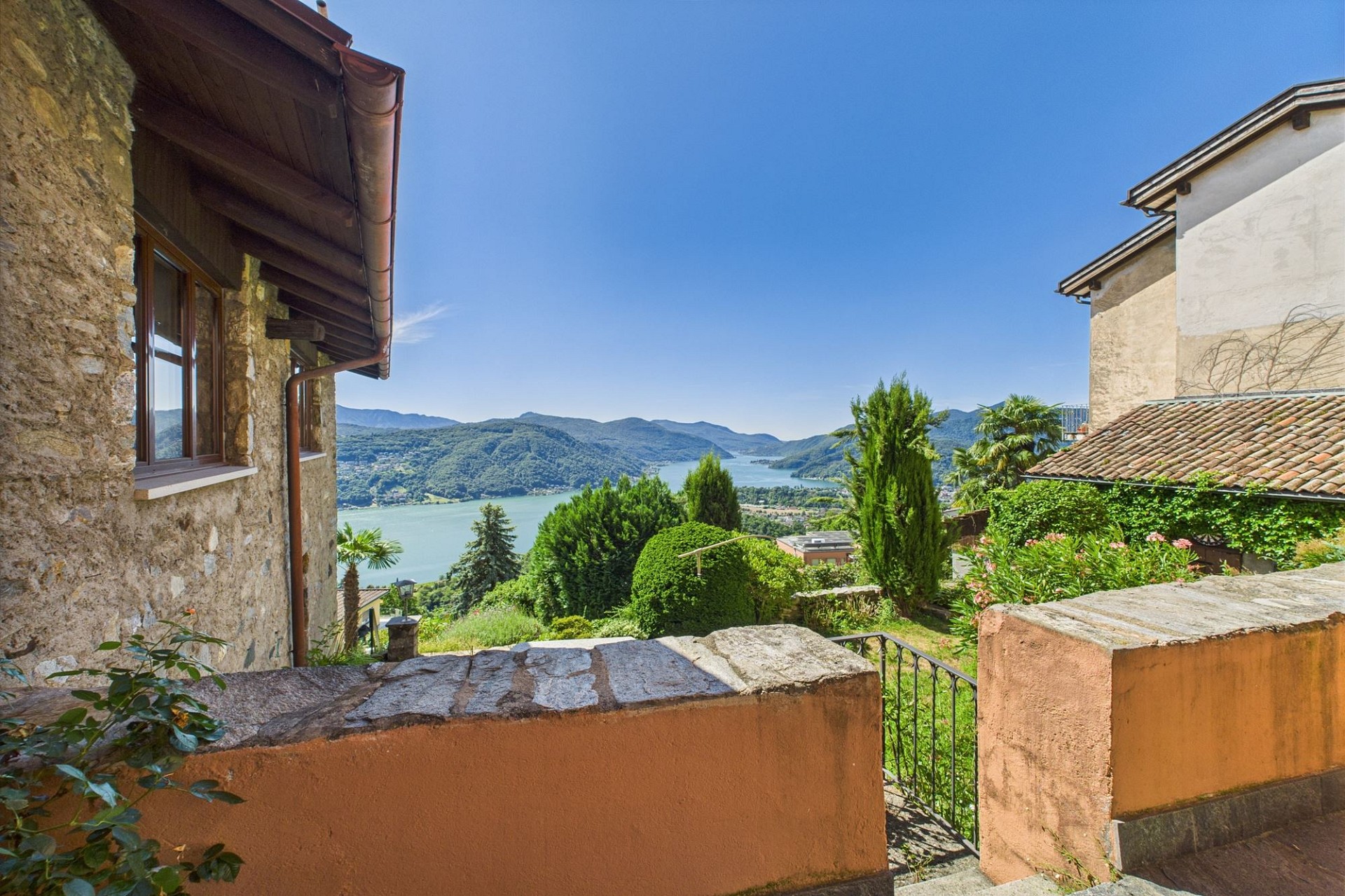 Seeblick zwischen Steinbauten und Garten