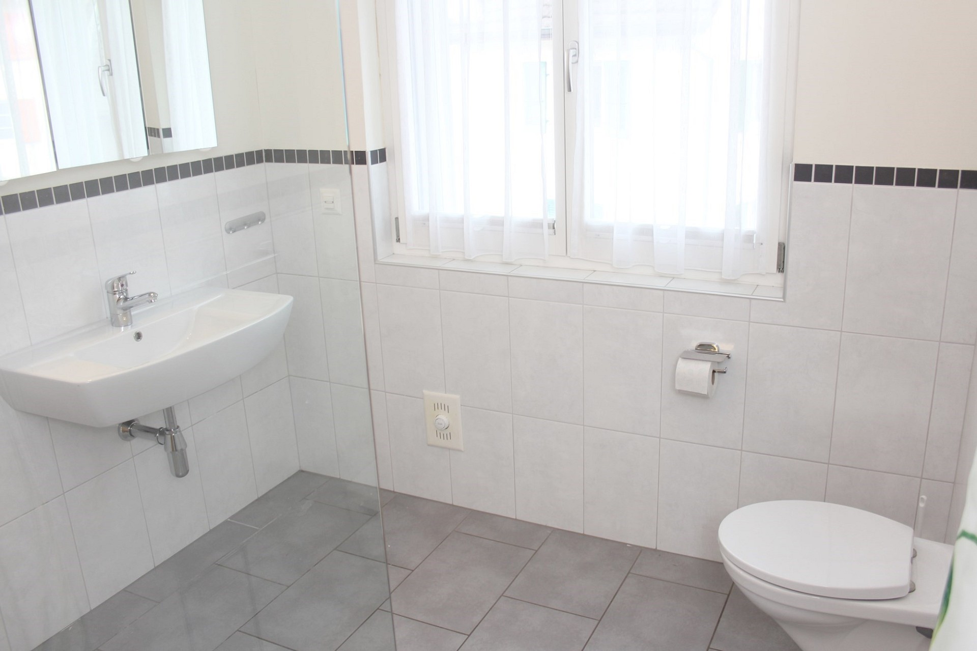 Helles Badezimmer mit wandhängendem WC und Waschtisch