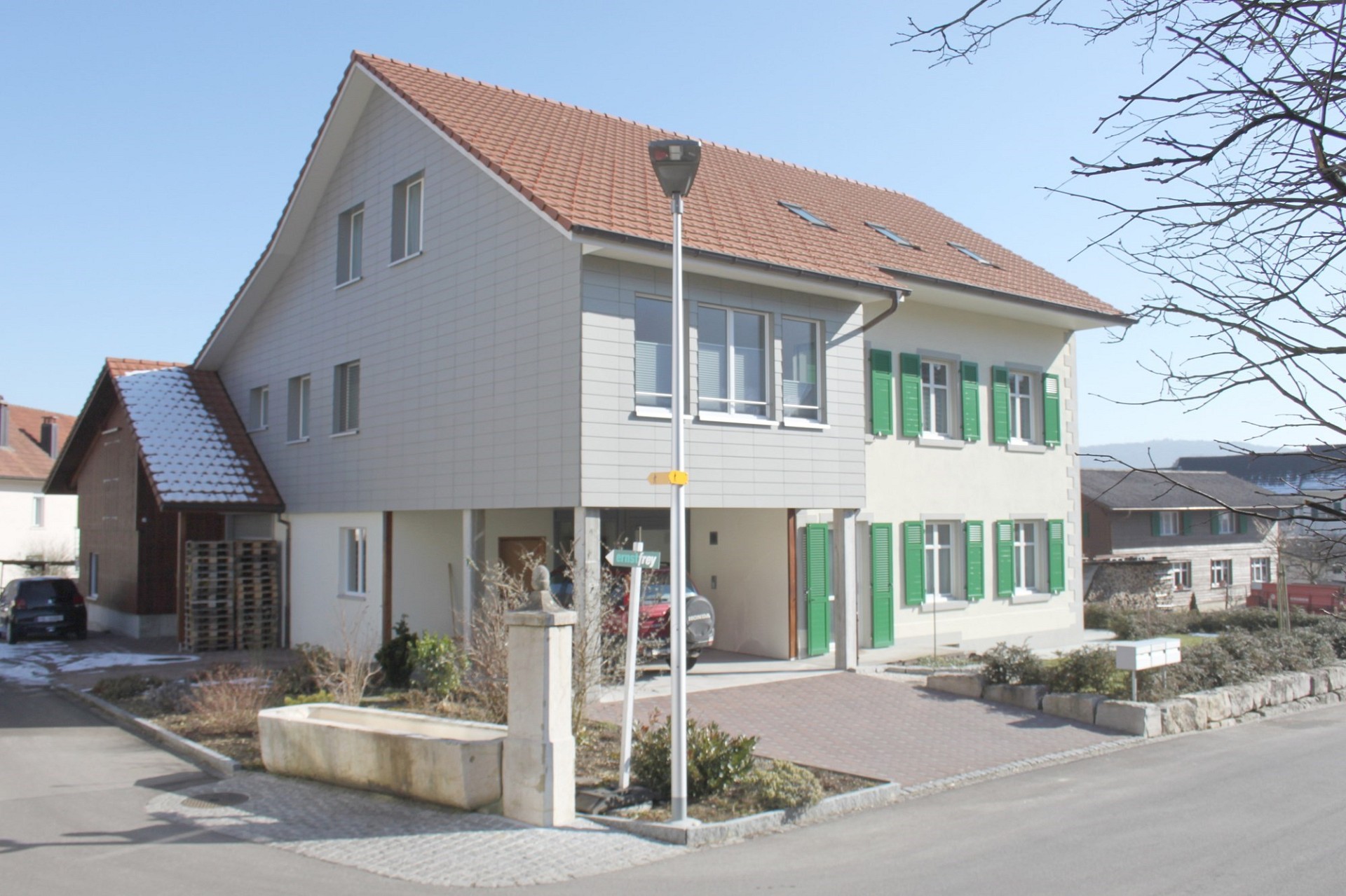 Wohnhaus mit Satteldach und grünen Fensterläden