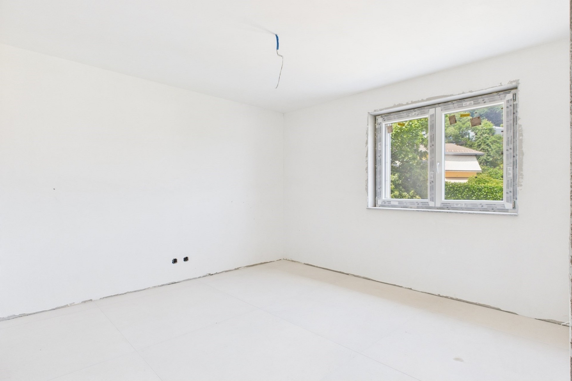 Leerer, frisch renovierter Raum mit Fenster