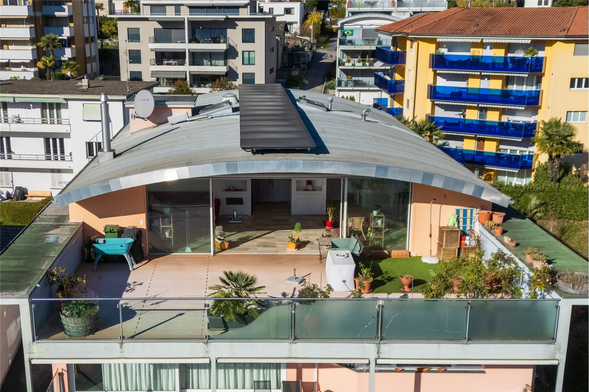 Dachterrasse mit geschwungenem Dach und umliegenden Wohnungen