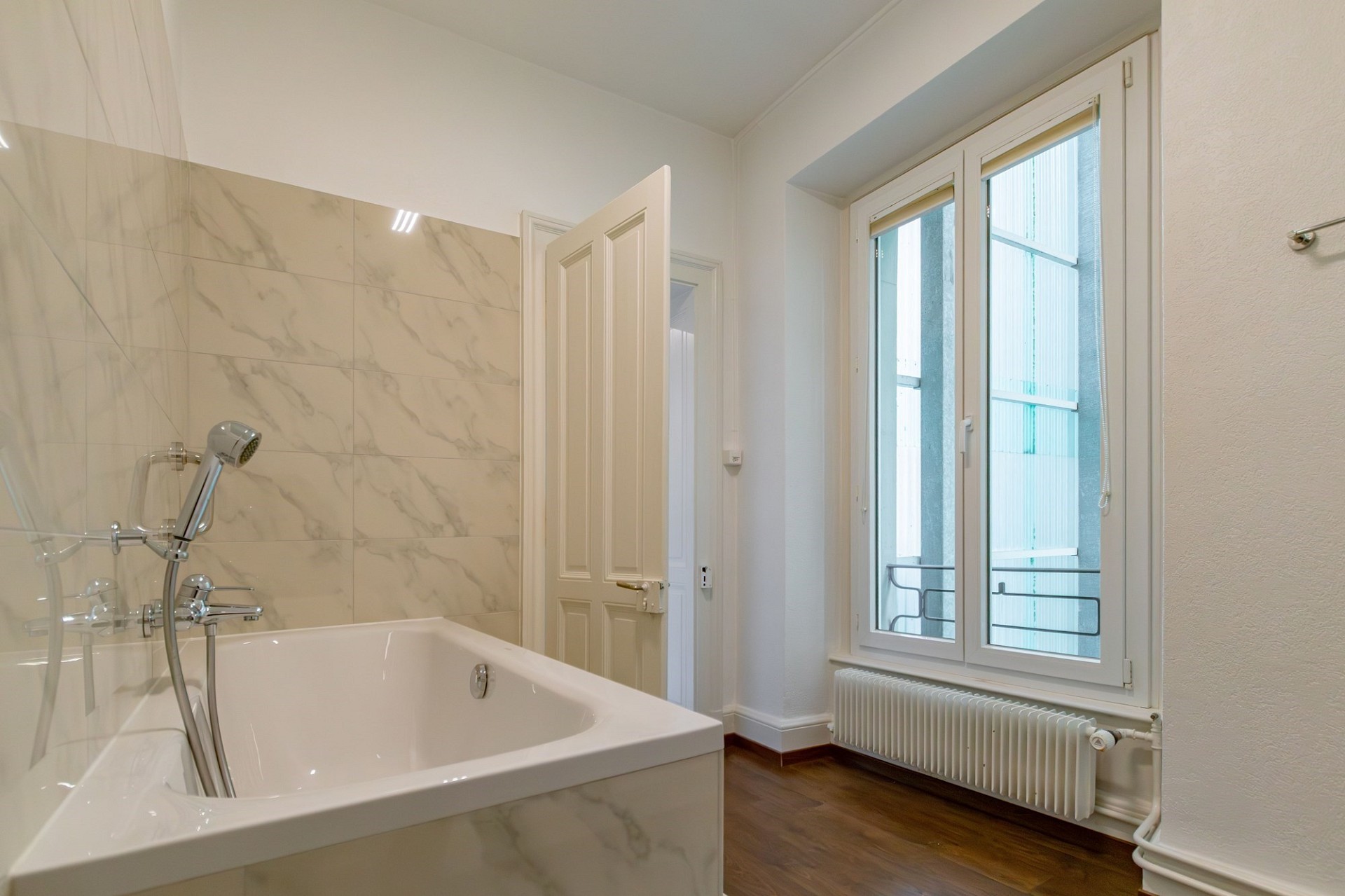 Modernes Badezimmer mit Badewanne und Fenster