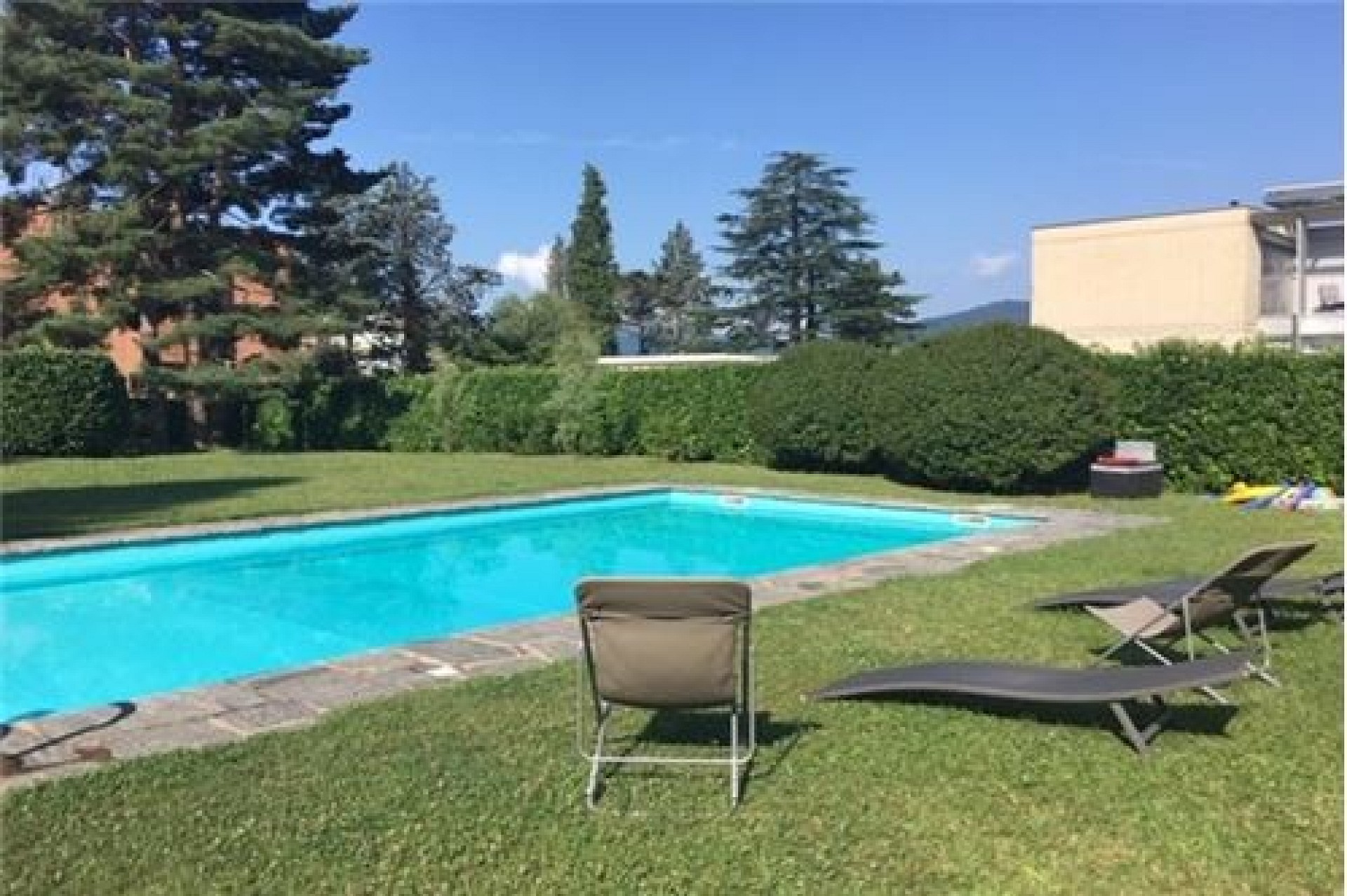 Außenbereich mit Pool und Liegestühlen