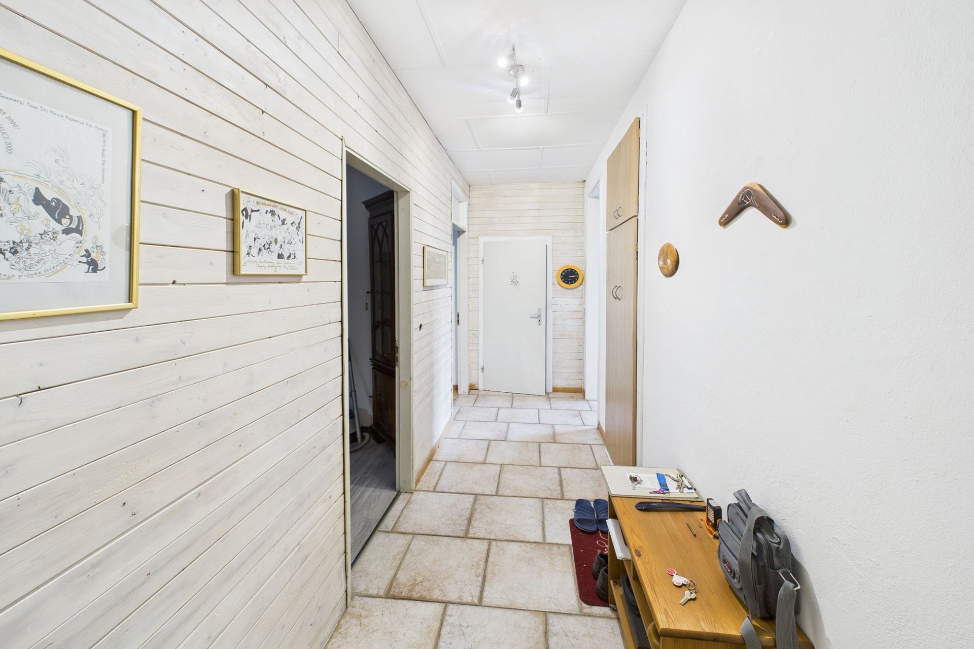 Heller Eingangsflur mit Holzpaneelen und Steinboden