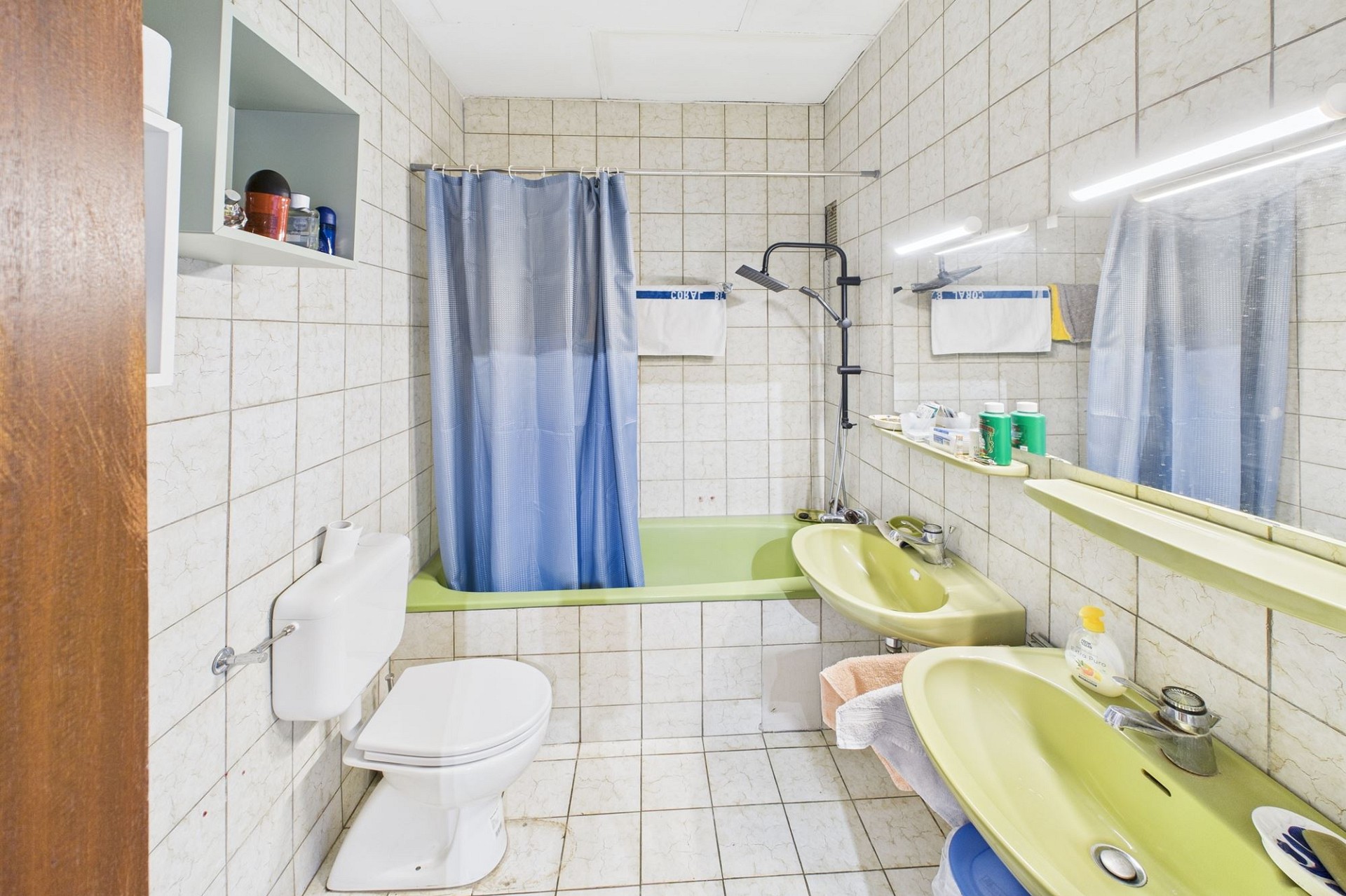 Kleines, schlichtes Badezimmer mit Badewanne und Toilette