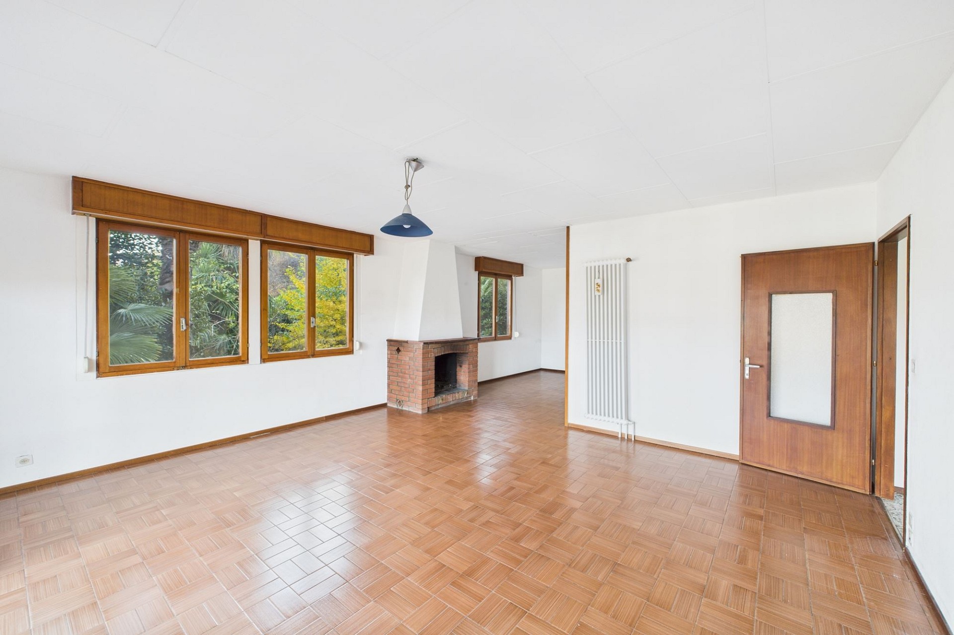 Heller Wohnraum mit Kamin und Parkettboden