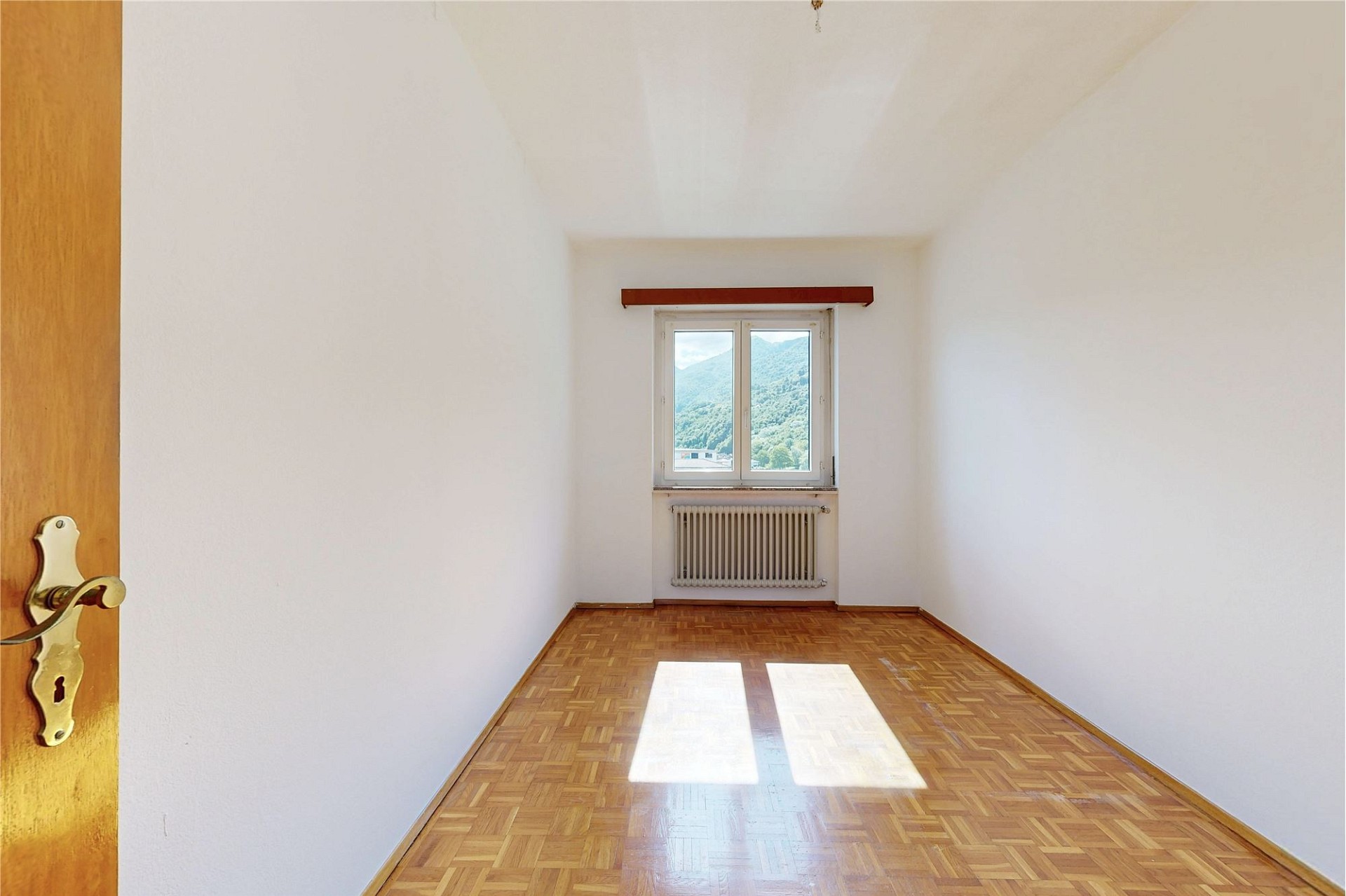 Leerer, heller Raum mit Parkett und Bergblick