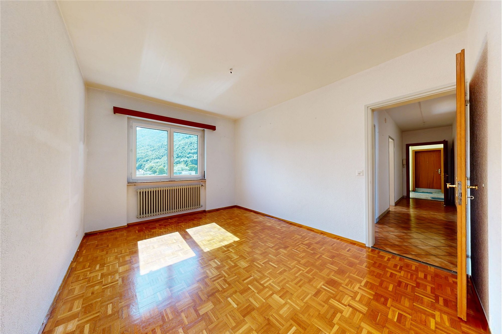 Leeres Zimmer mit Parkett und Fensterblick