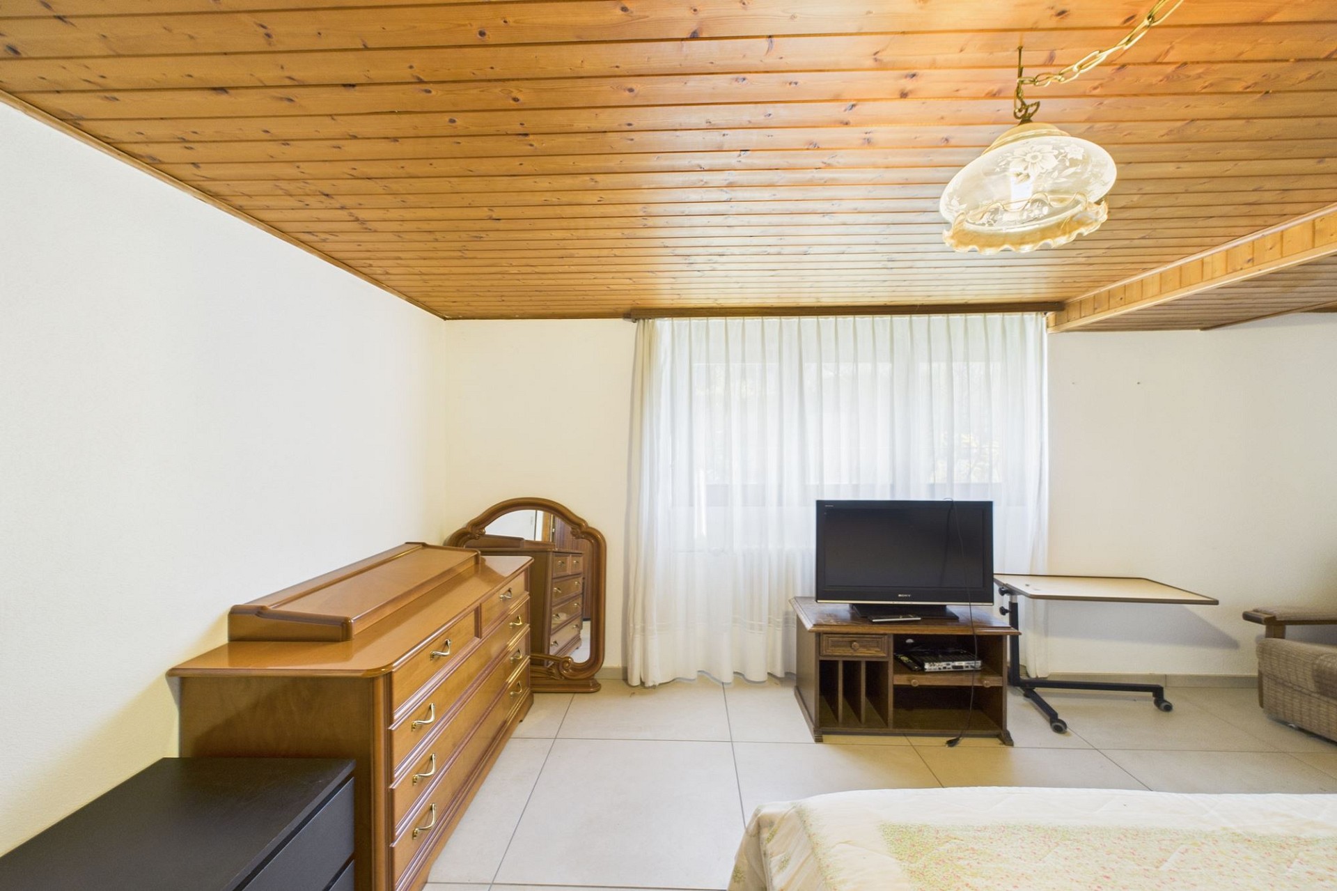 Schlichtes Schlafzimmer mit Holzdecke
