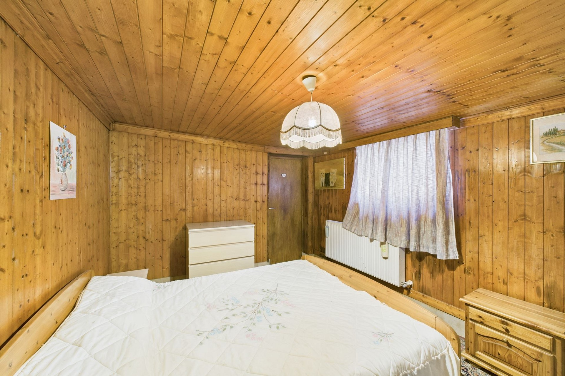 Rustikal eingerichtetes Schlafzimmer mit Holzverkleidung