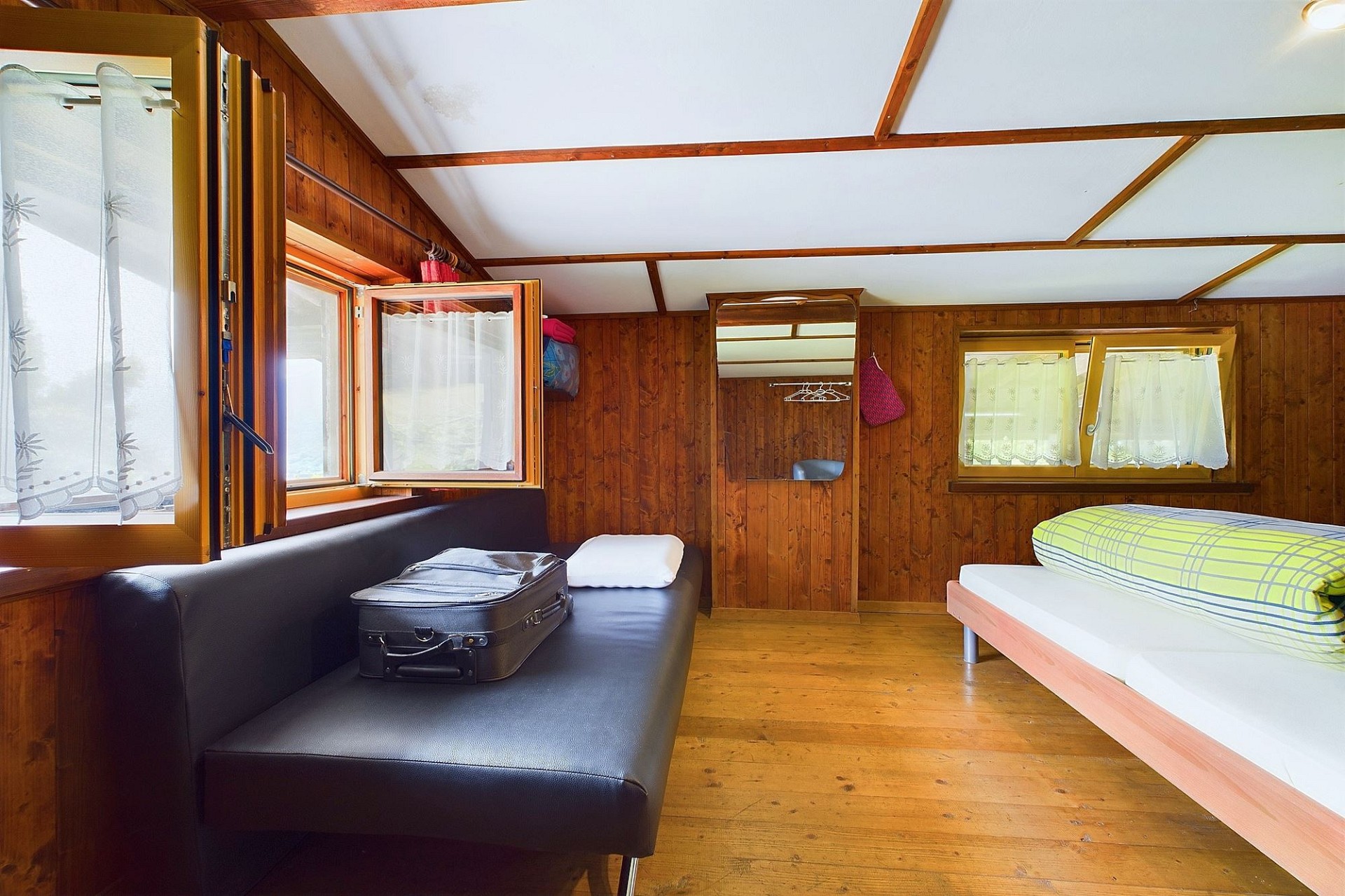 Gemütliches Holz-Schlafzimmer mit Sitzgelegenheit