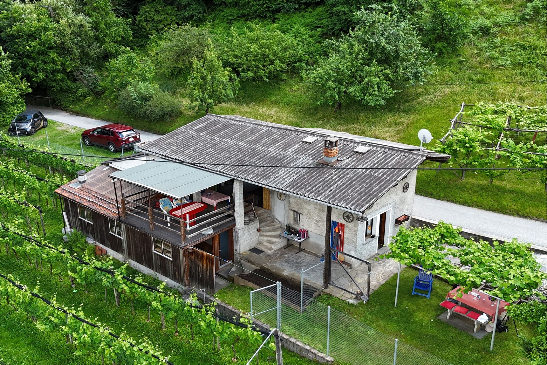 Luftaufnahme eines ländlichen Wohnhauses mit Weinberg und Terrasse