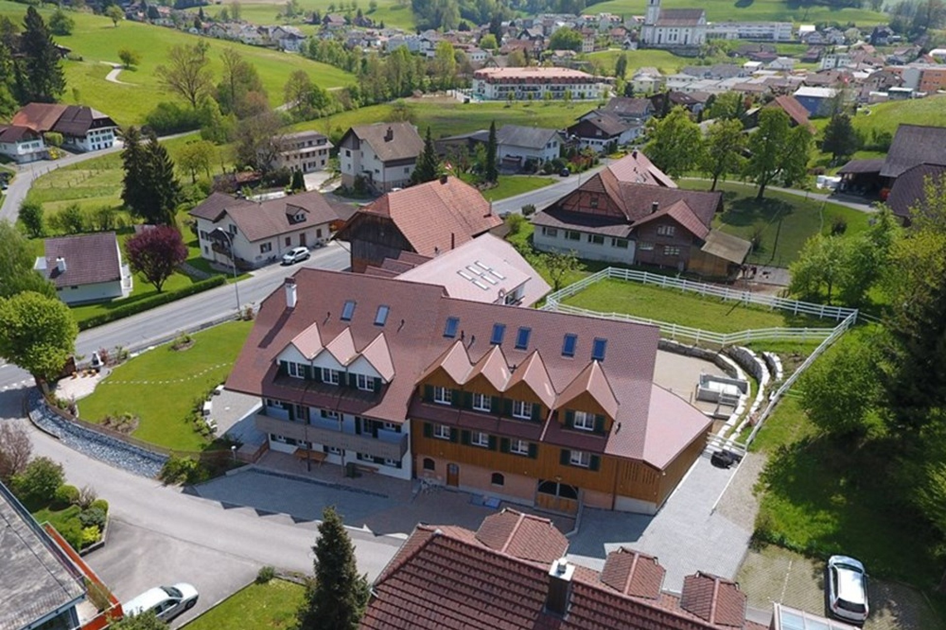 Luftaufnahme eines ländlichen Wohngebiets mit großem Mehrfamilienhaus oder Wohngebäude