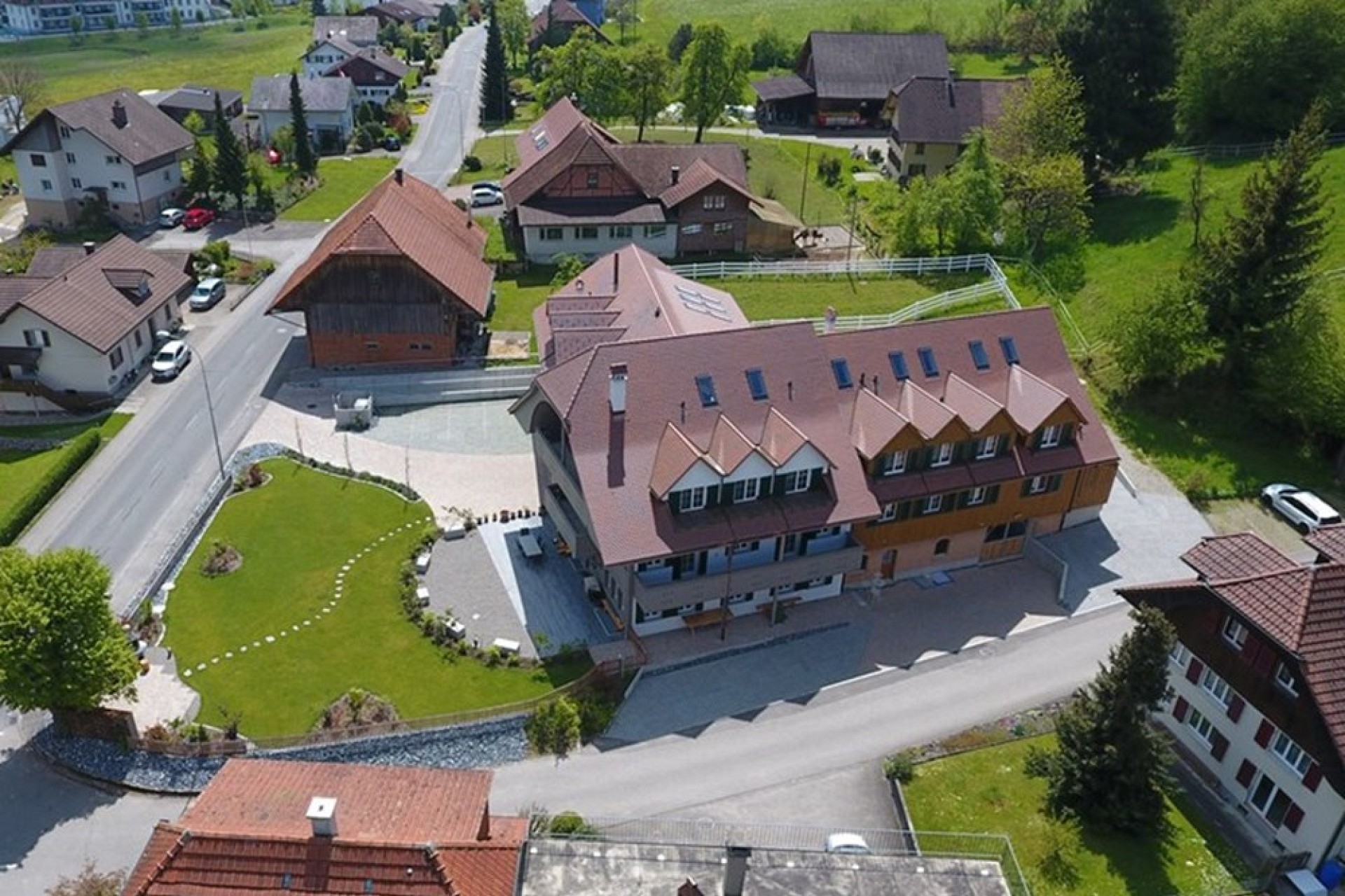 Luftaufnahme eines Wohngebiets mit landhausartigem Mehrfamilienhaus