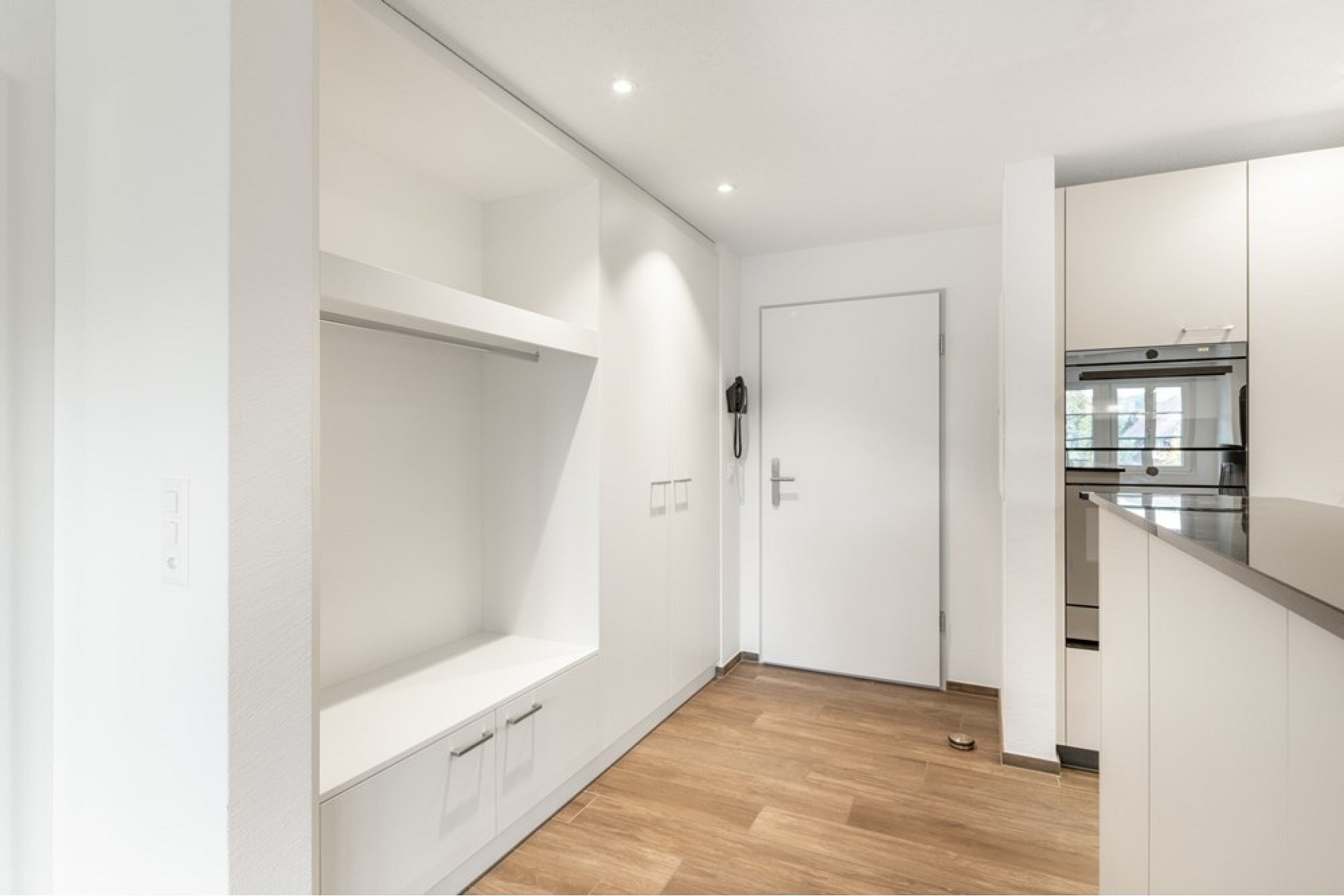Heller Eingangsbereich mit Einbauschrank und Küche