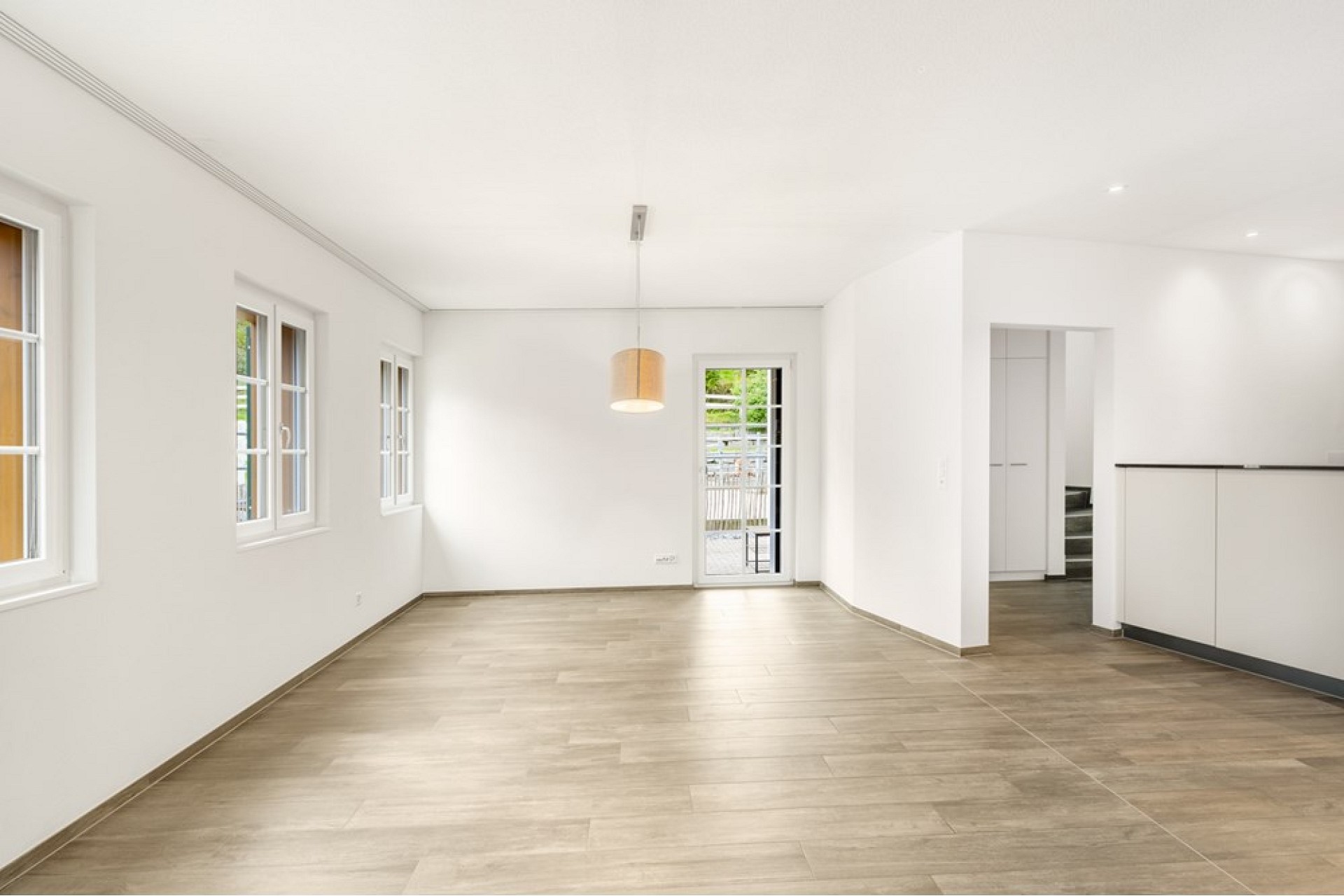 Heller Wohnbereich mit Terrasse und offener Übergang zu Nebenraum