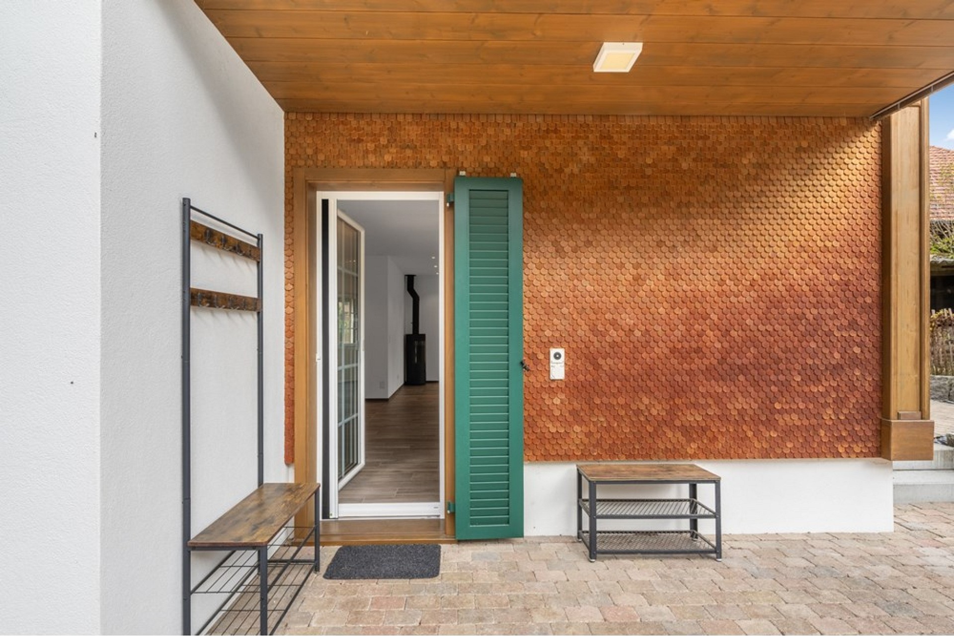 Überdachter Hauseingang mit Holzfassade