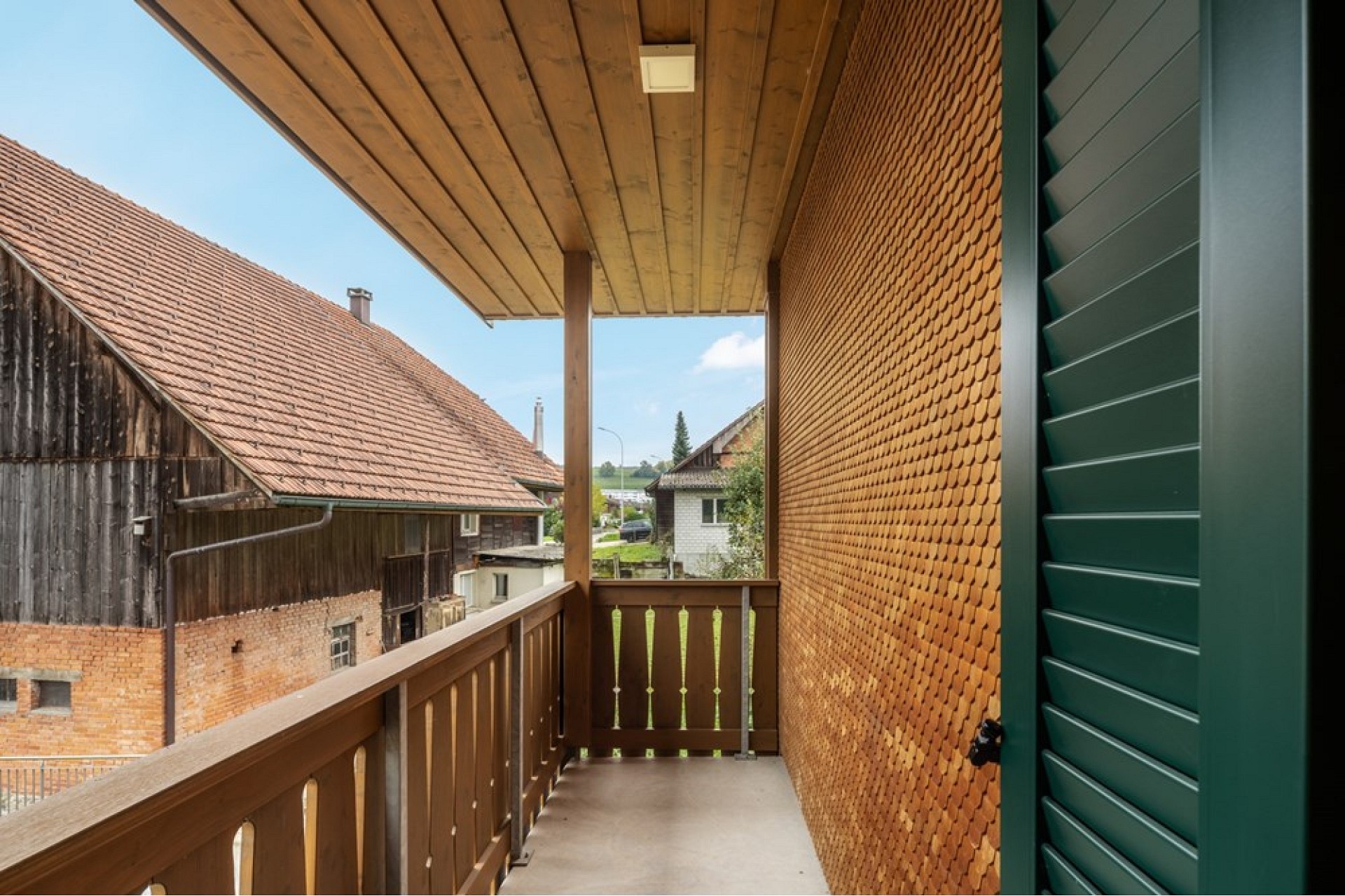 Balkon mit Holzgeländer und Blick ins Dorf