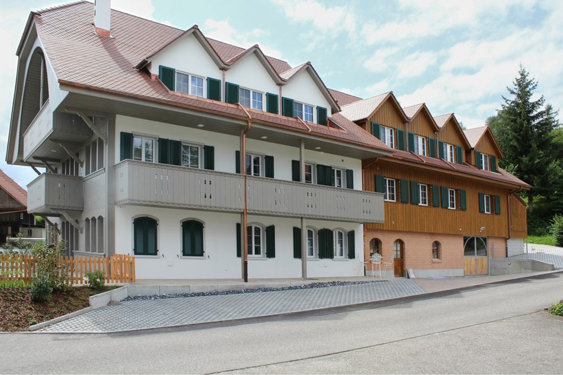 Mehrfamilienhaus mit Satteldach und Holzfassaden
