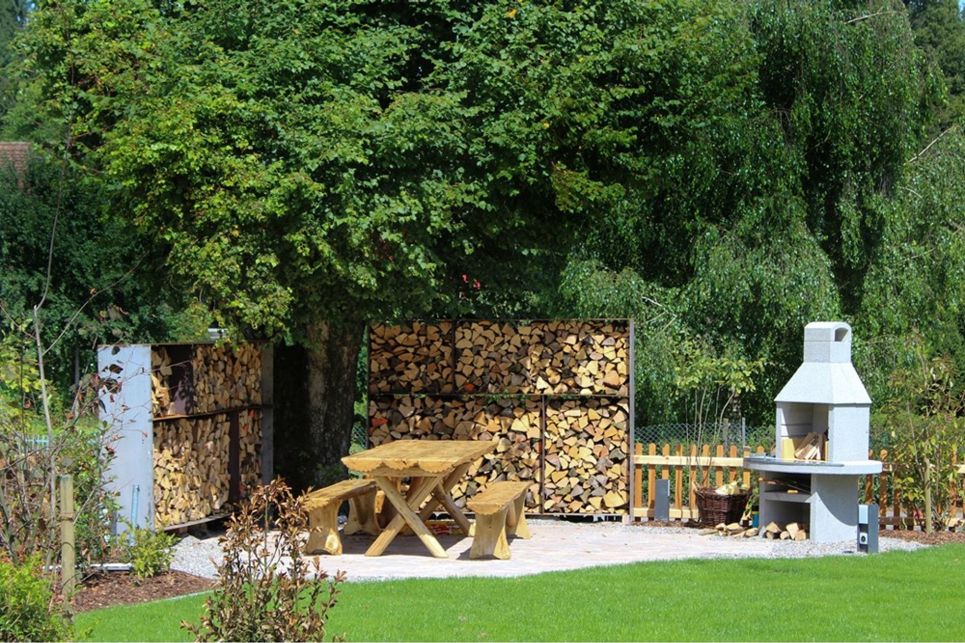 Garten mit Holzlager und Grillplatz