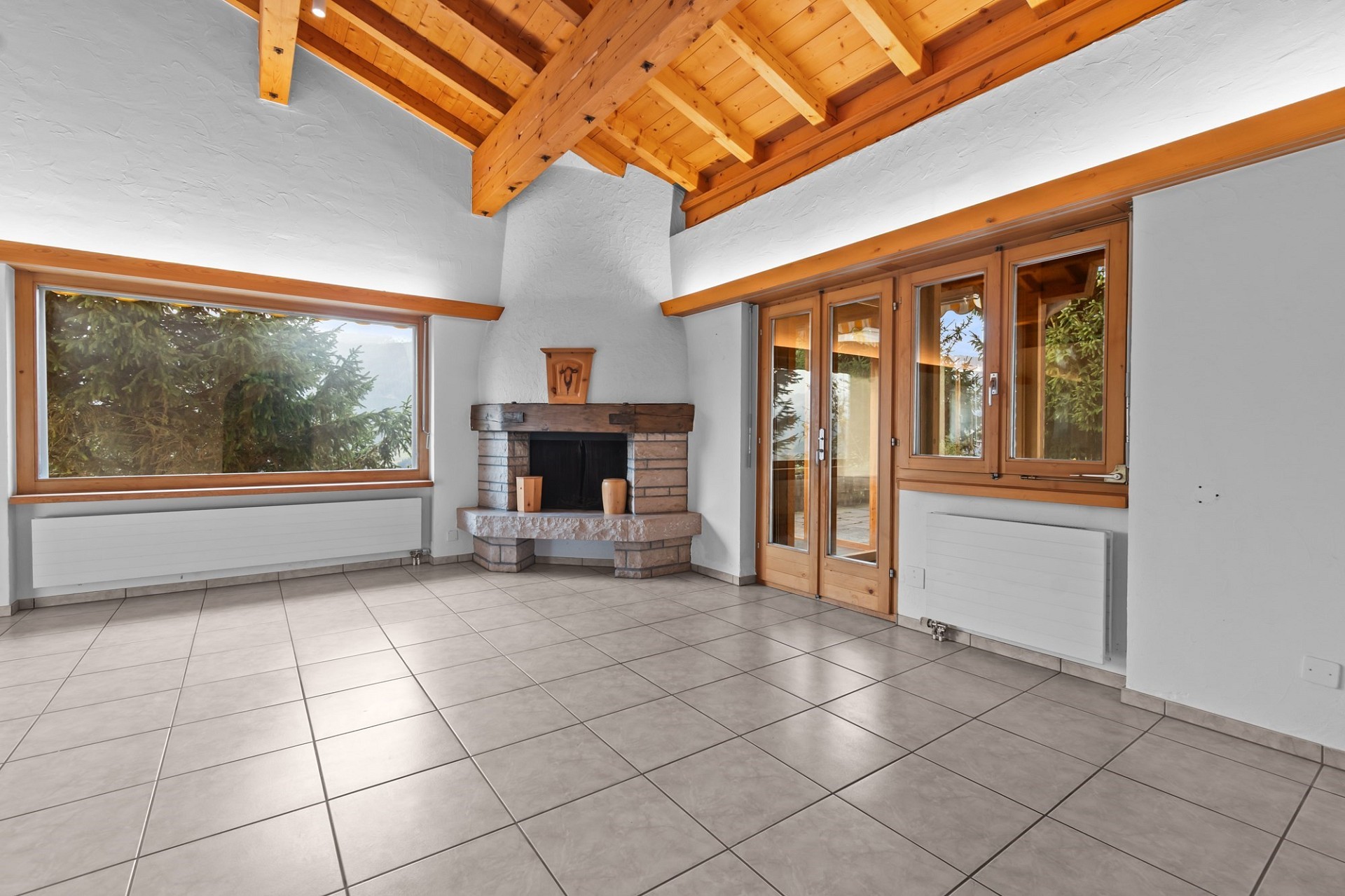 Heller Wohnraum mit Kamin und Holzbalkendecke
