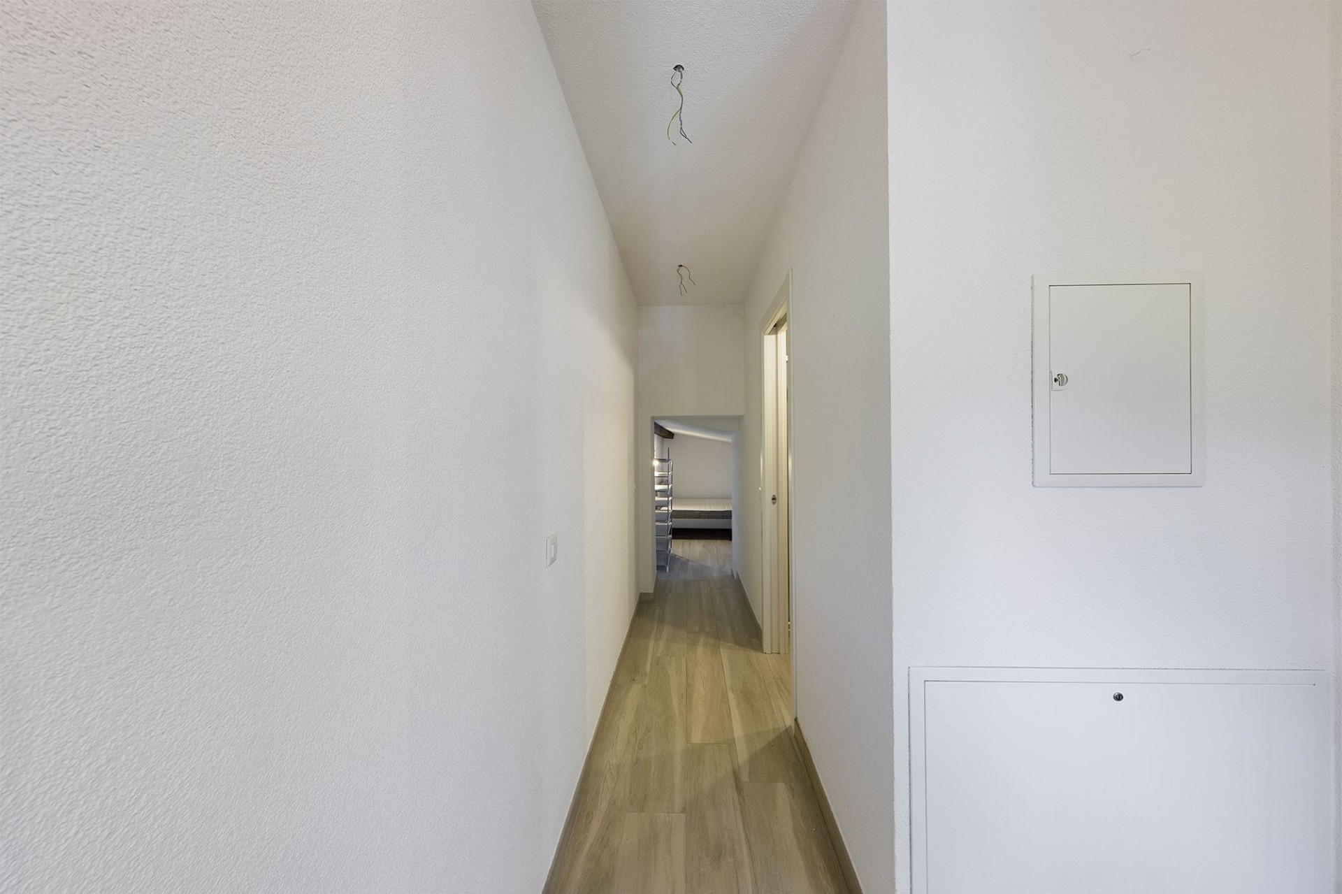 Schmaler Flur mit Blick in einen Raum