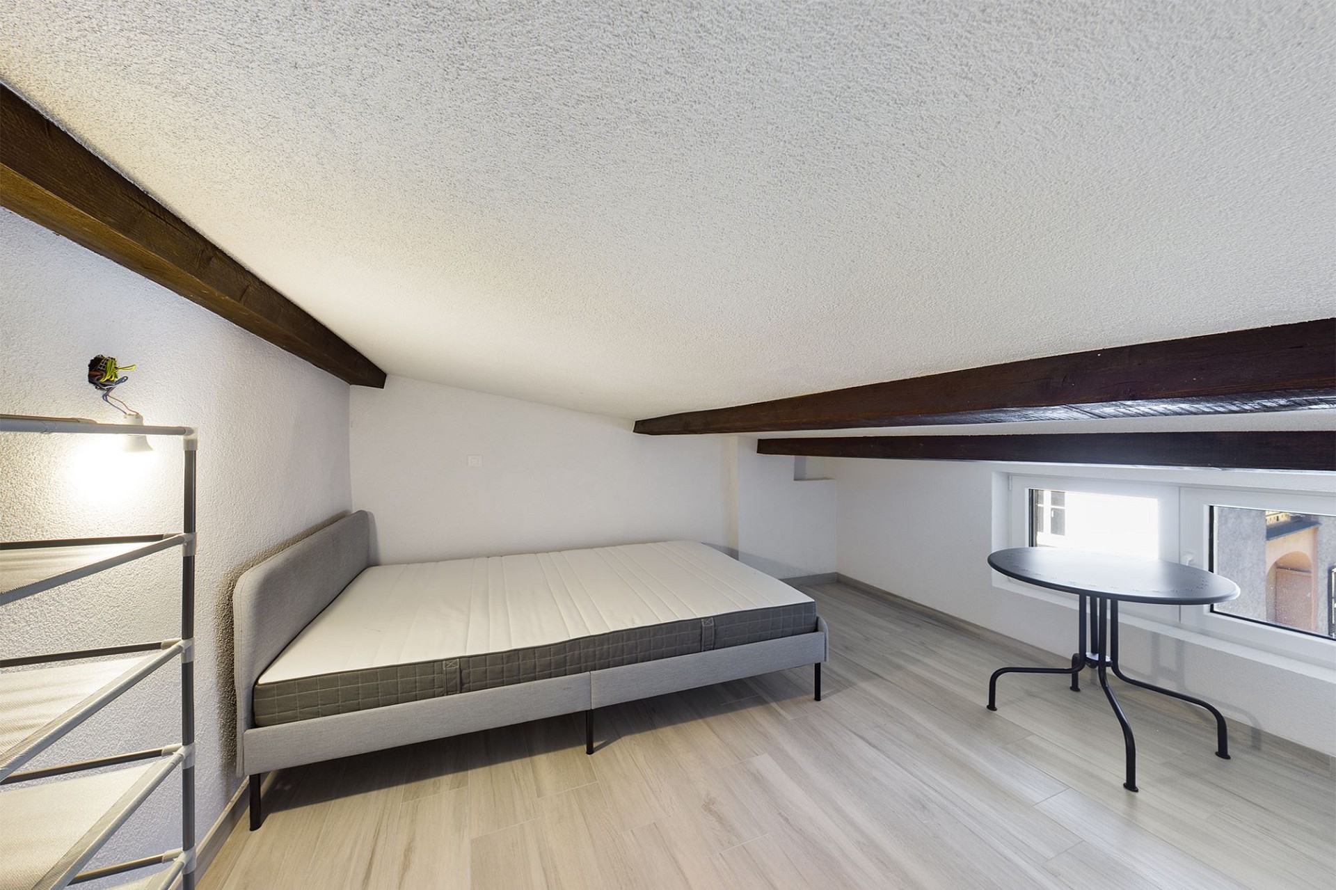 Dachzimmer mit Bett und Schreibtisch