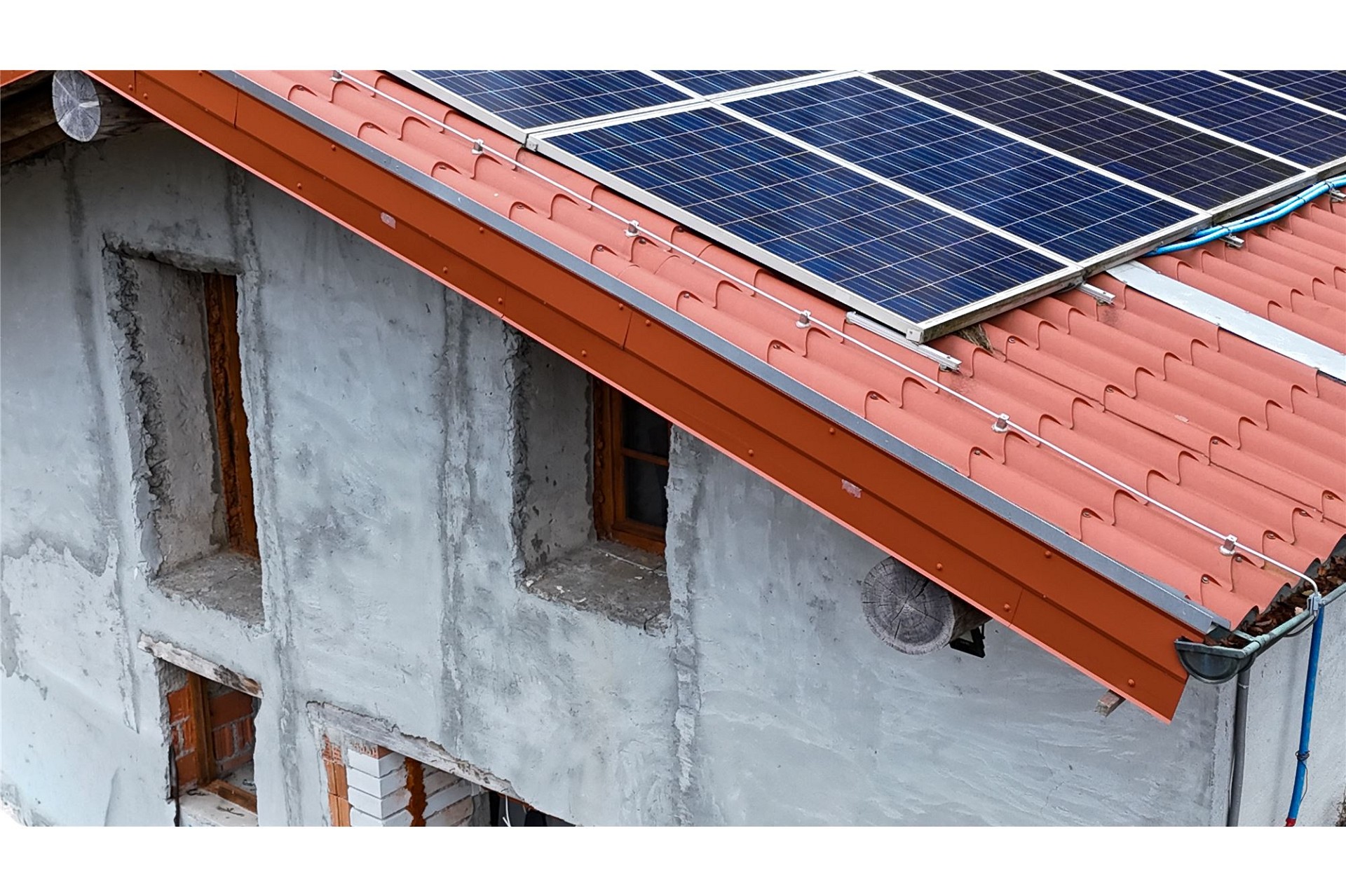 Dach mit Solarmodulen und unsaniert wirkender Fassade