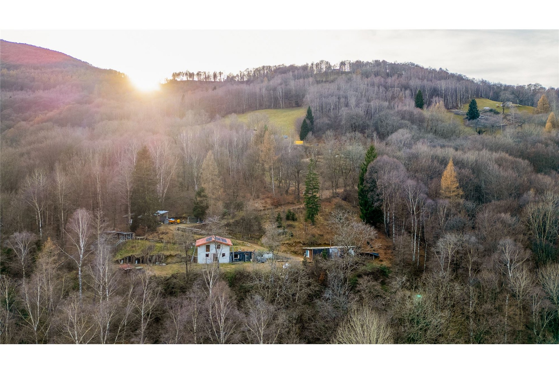 Ländliches Grundstück mit Waldhang und Sonnenuntergang