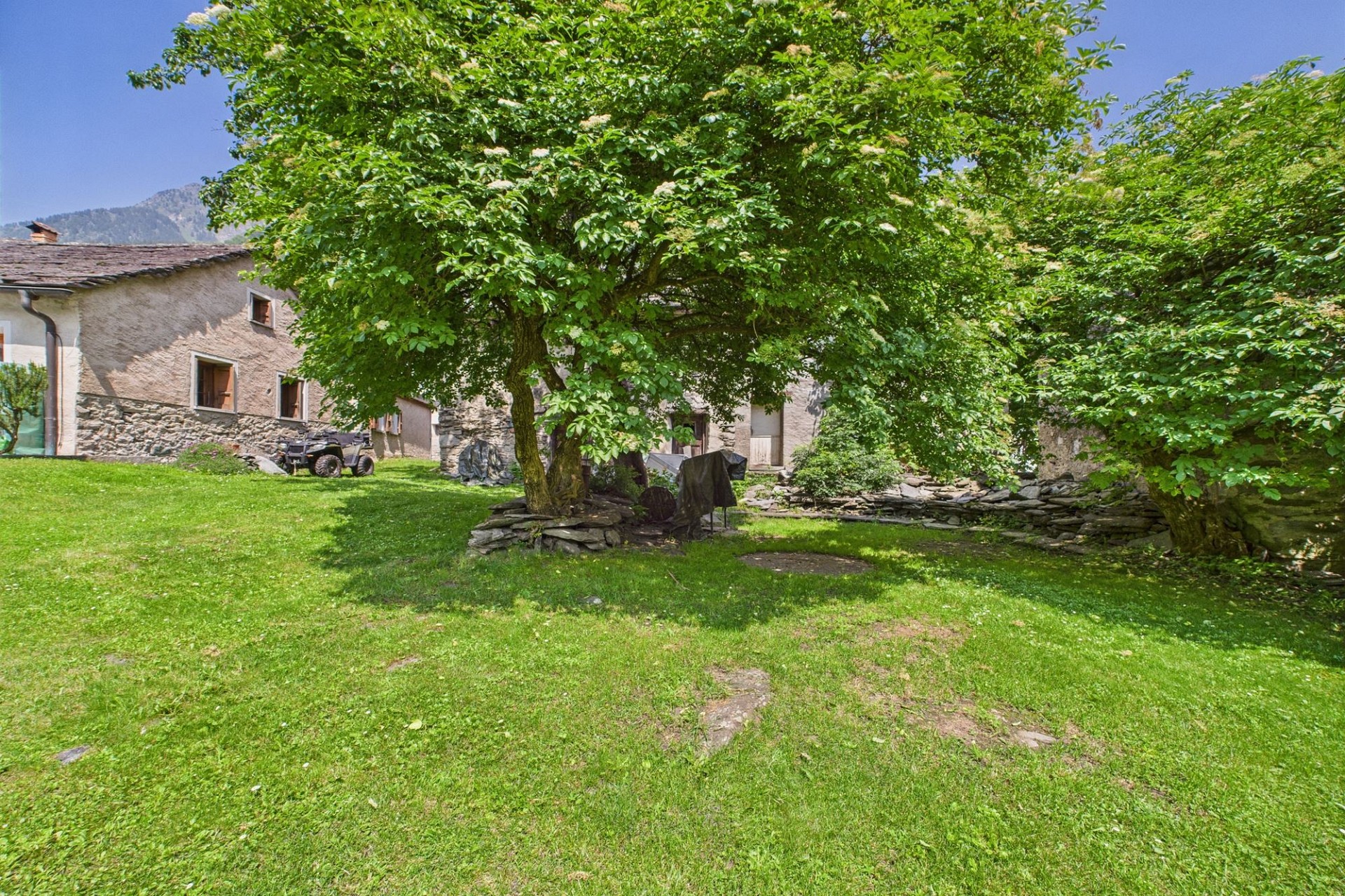 Ländlicher Garten mit altem Steinhaus