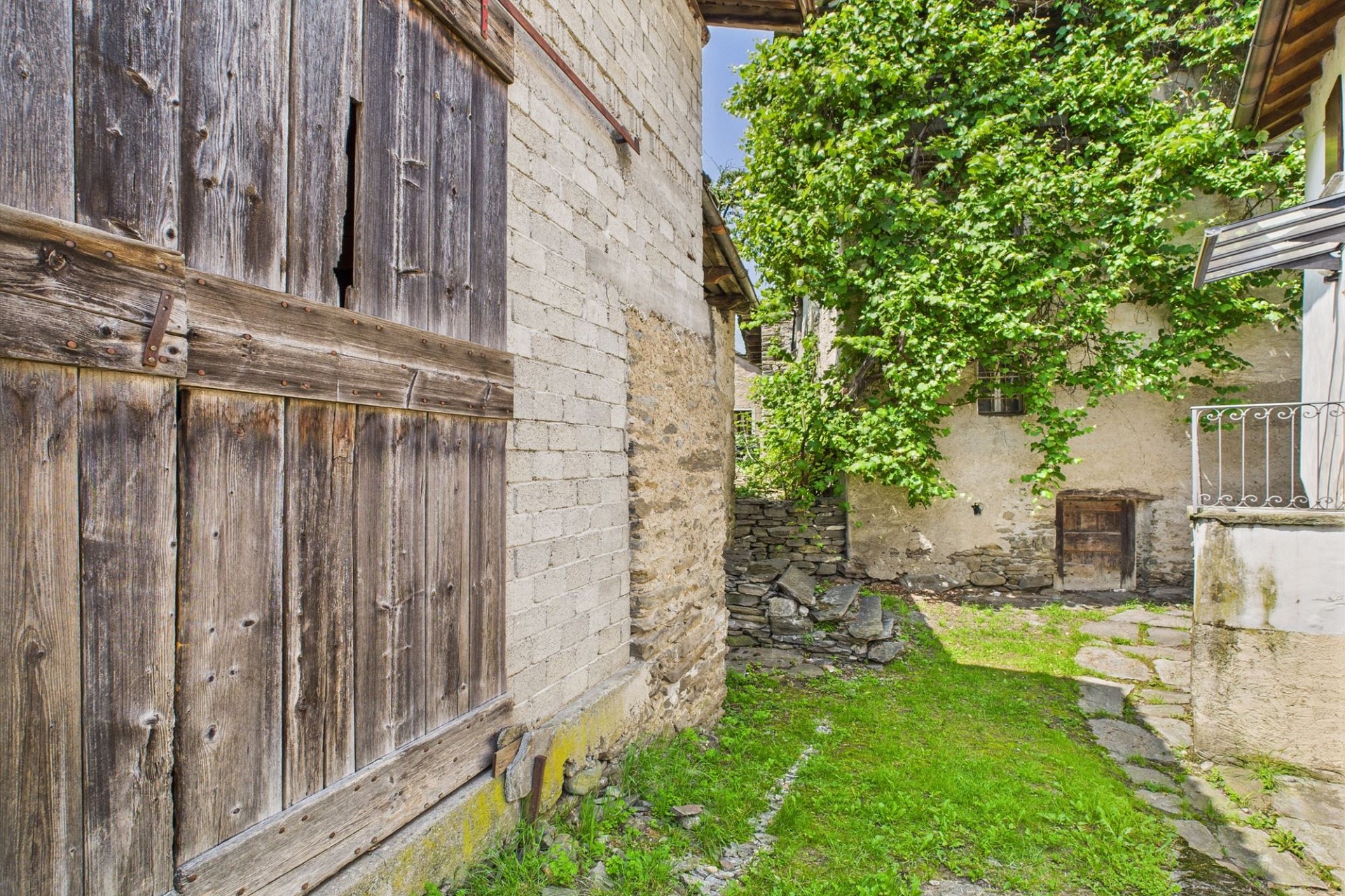 Historischer Innenhof mit Holztor und Steinmauer