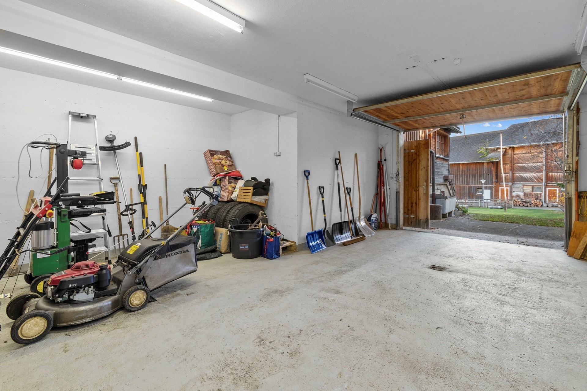 Garage mit offenem Tor und Gartenausblick
