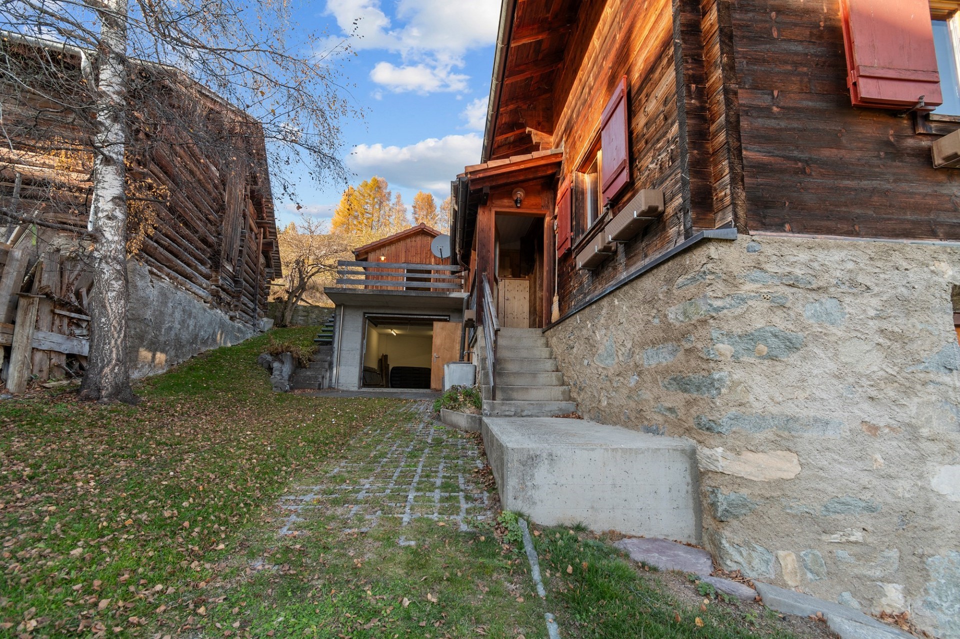 Rustikales Holzhaus mit steinernem Sockel und Außenaufgang