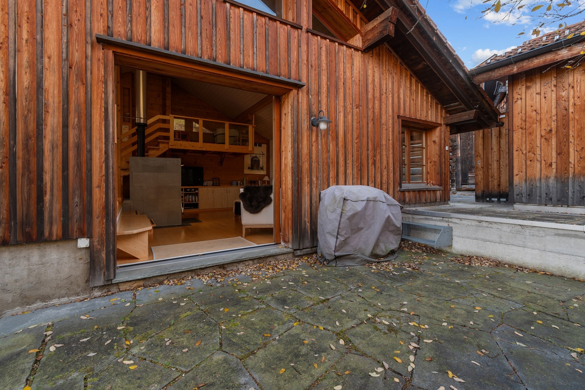 Rustikale Holzfassade mit Innenhof und sichtbarem Wohnbereich