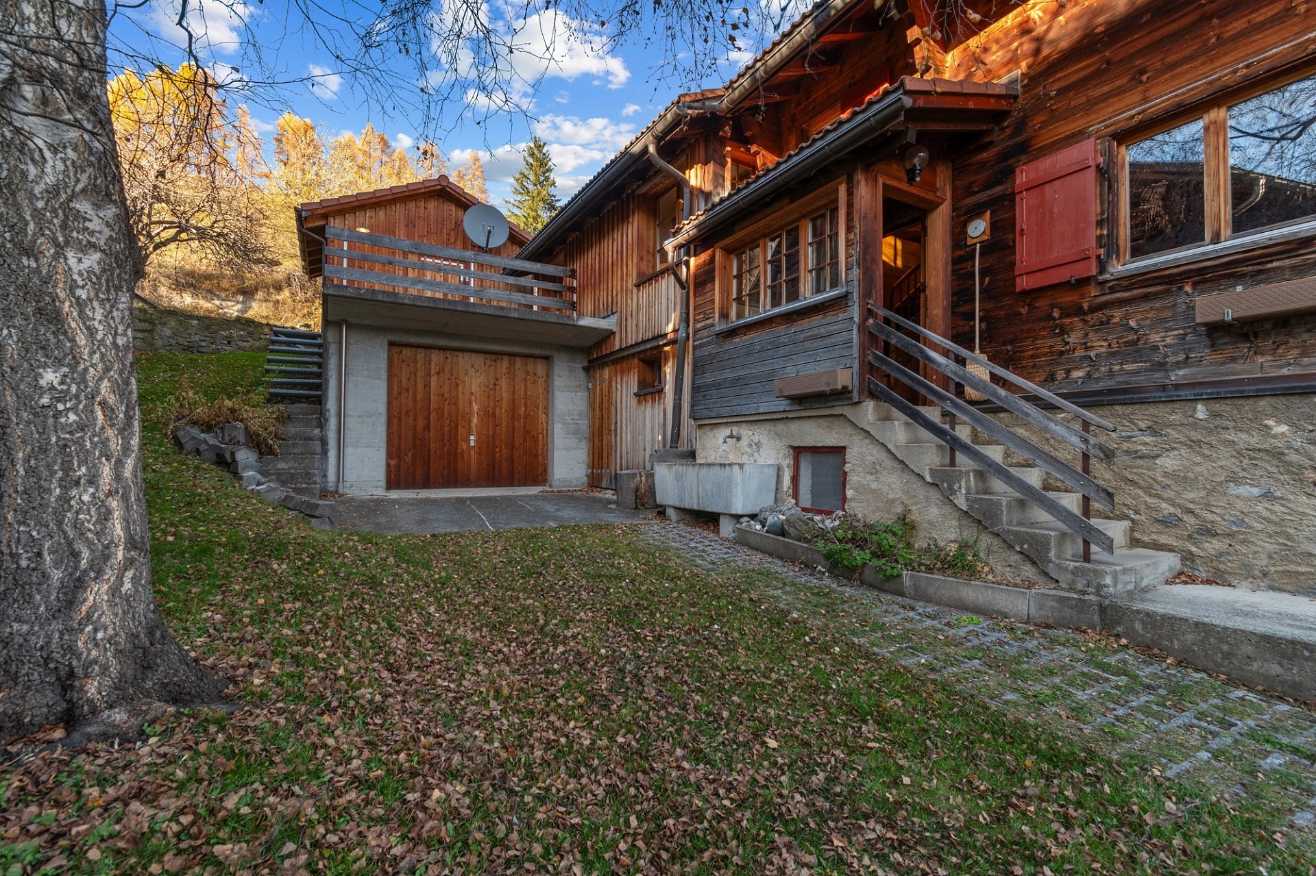 Rustikales Holzhaus mit Garage und Außentreppe