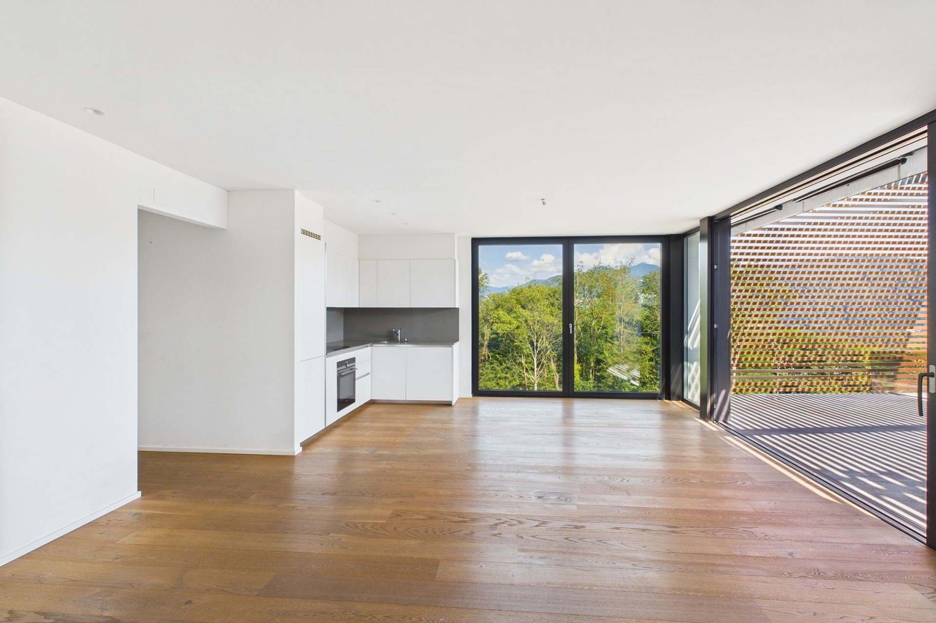 Offener Wohnbereich mit Küche und Balkon