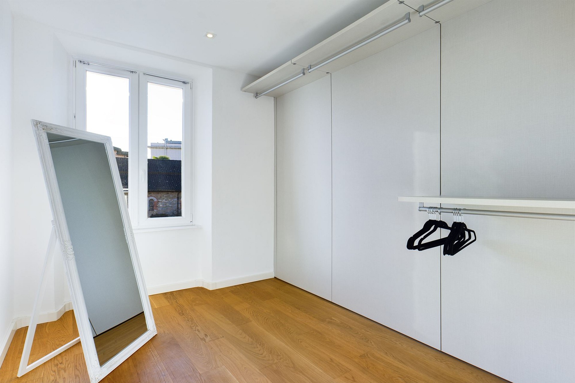 Helles Ankleidezimmer mit Einbauschrank und Spiegel