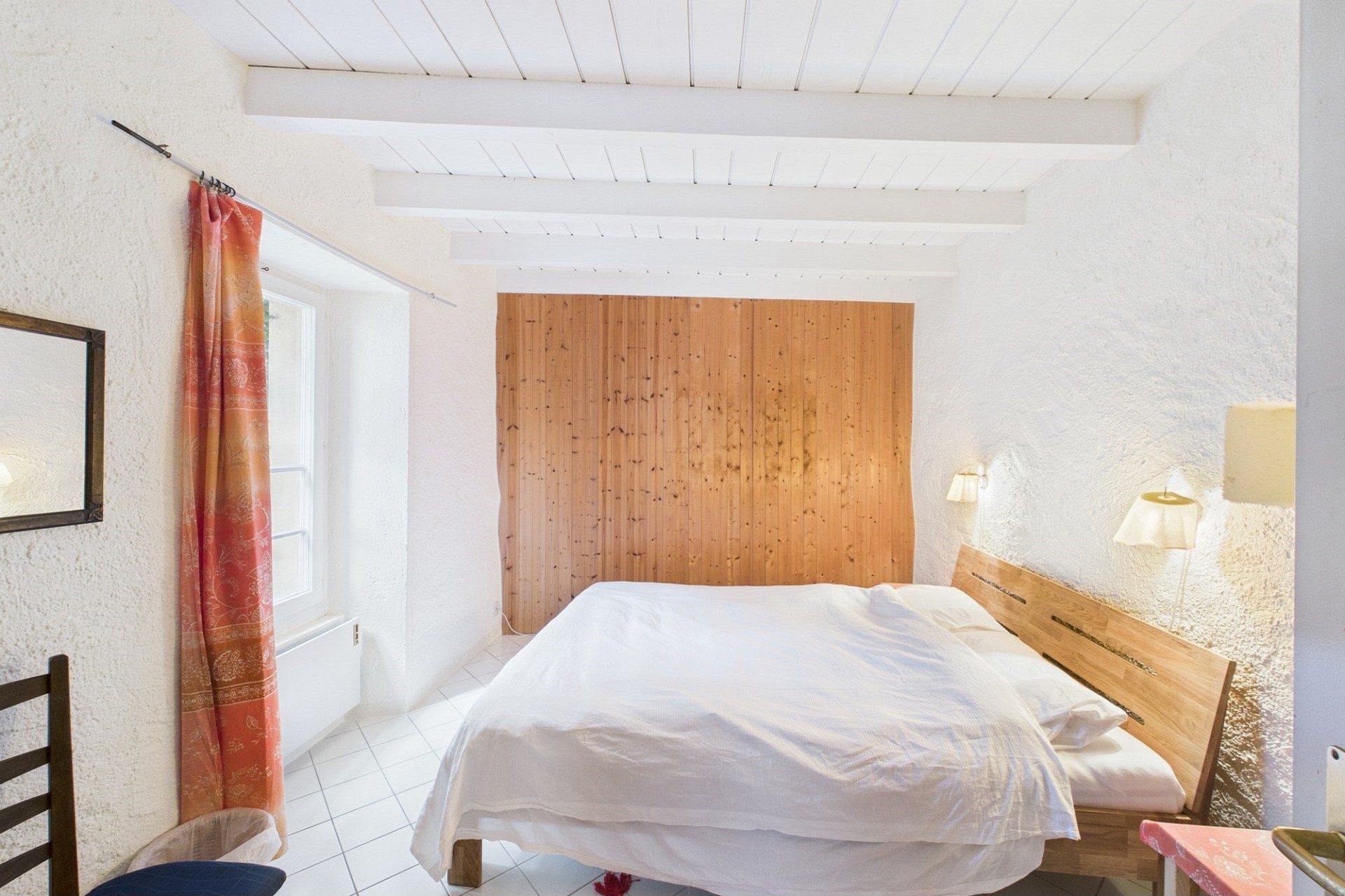 Helles Schlafzimmer mit Holzverkleidung und weißer Decke