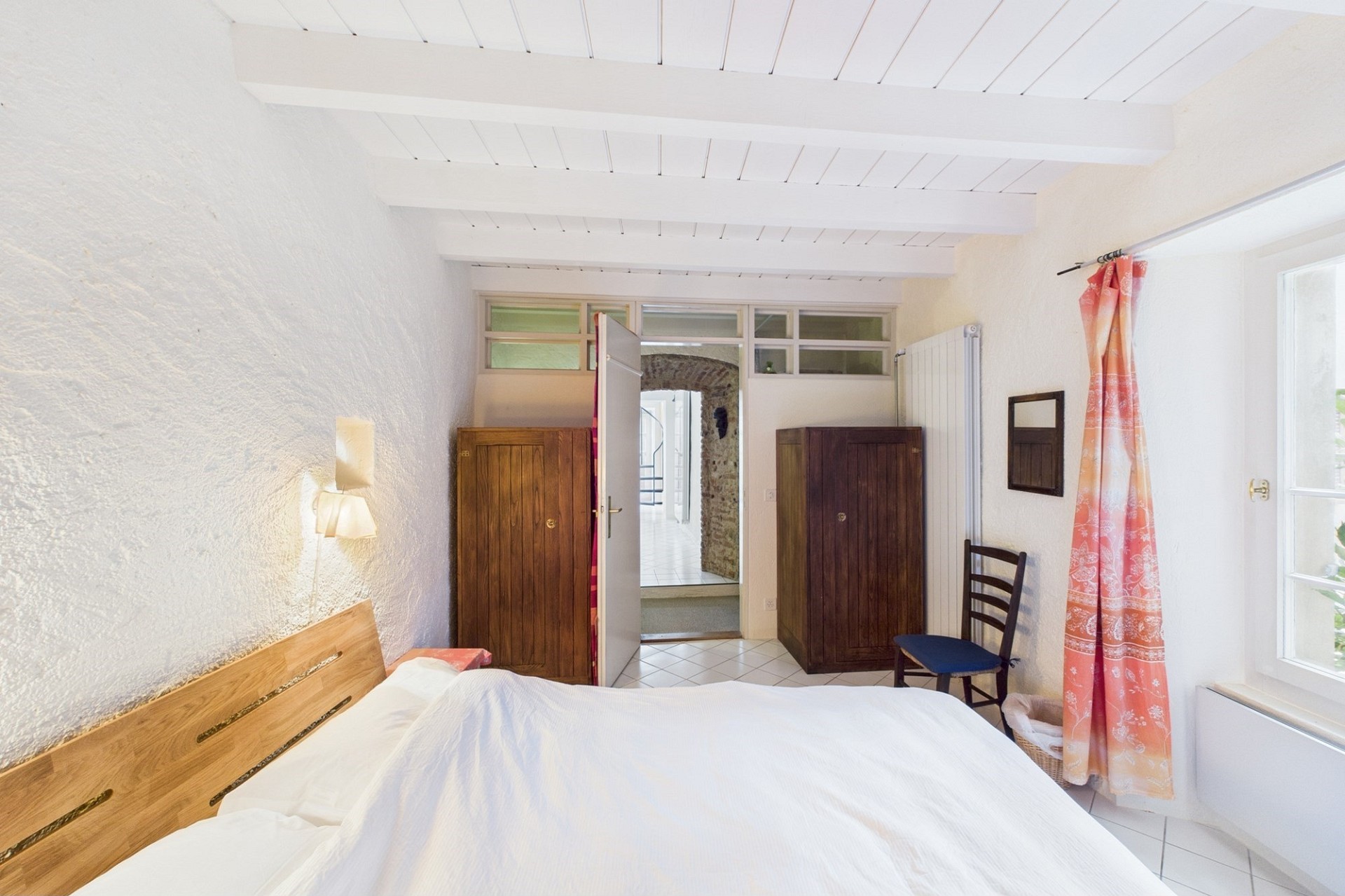 Helles Schlafzimmer mit weißem Gewölbe und Holzbalken