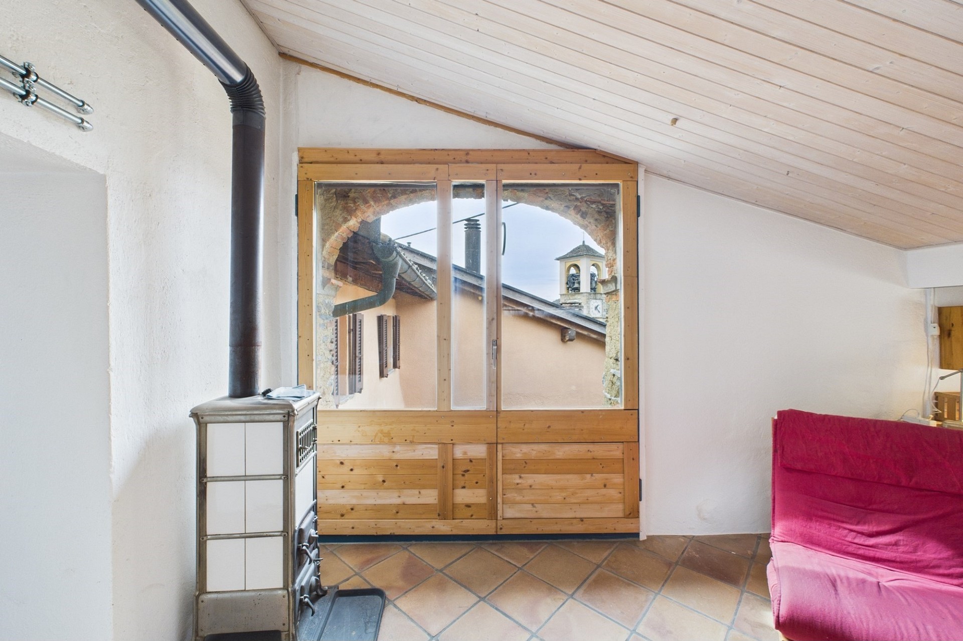 Dachzimmer mit Holzofen und Blick nach draußen