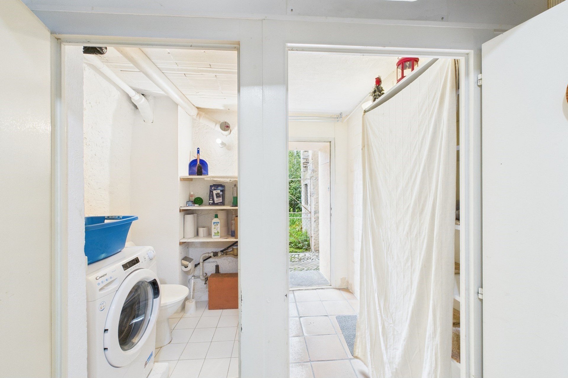 Hauswirtschaftsraum mit Waschmaschine und Durchgang