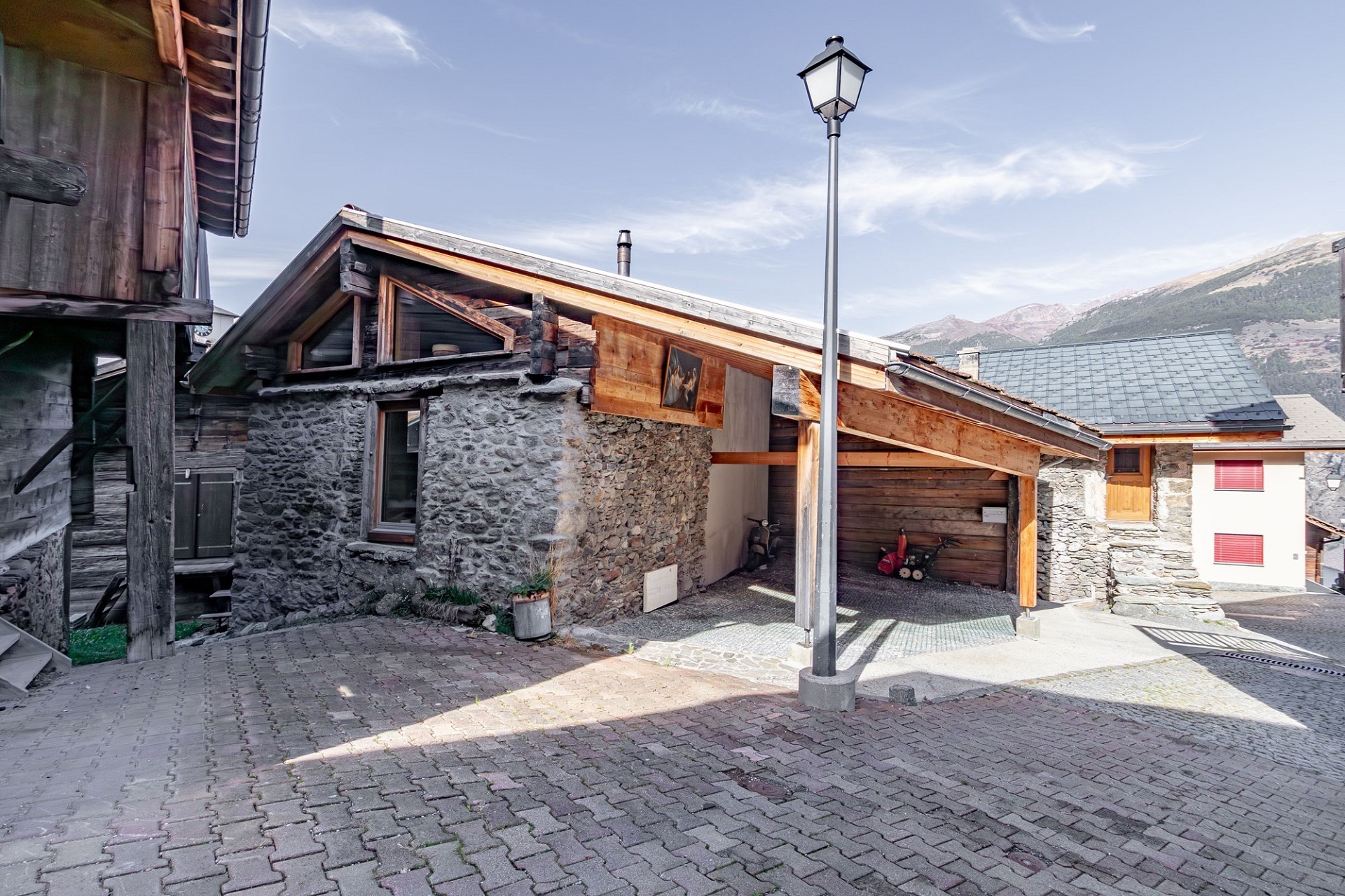 Alpine Außenansicht mit rustikalen Gebäuden und Carport