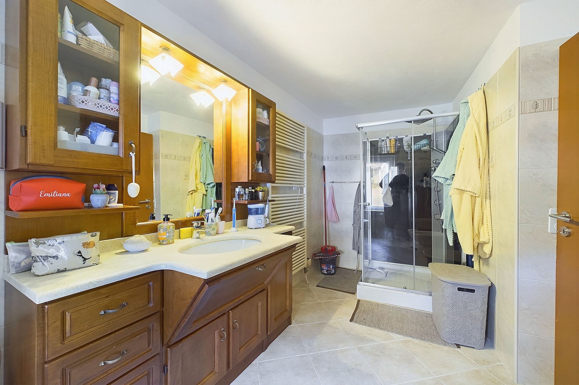 Helles Badezimmer mit Holzschrank und Dusche